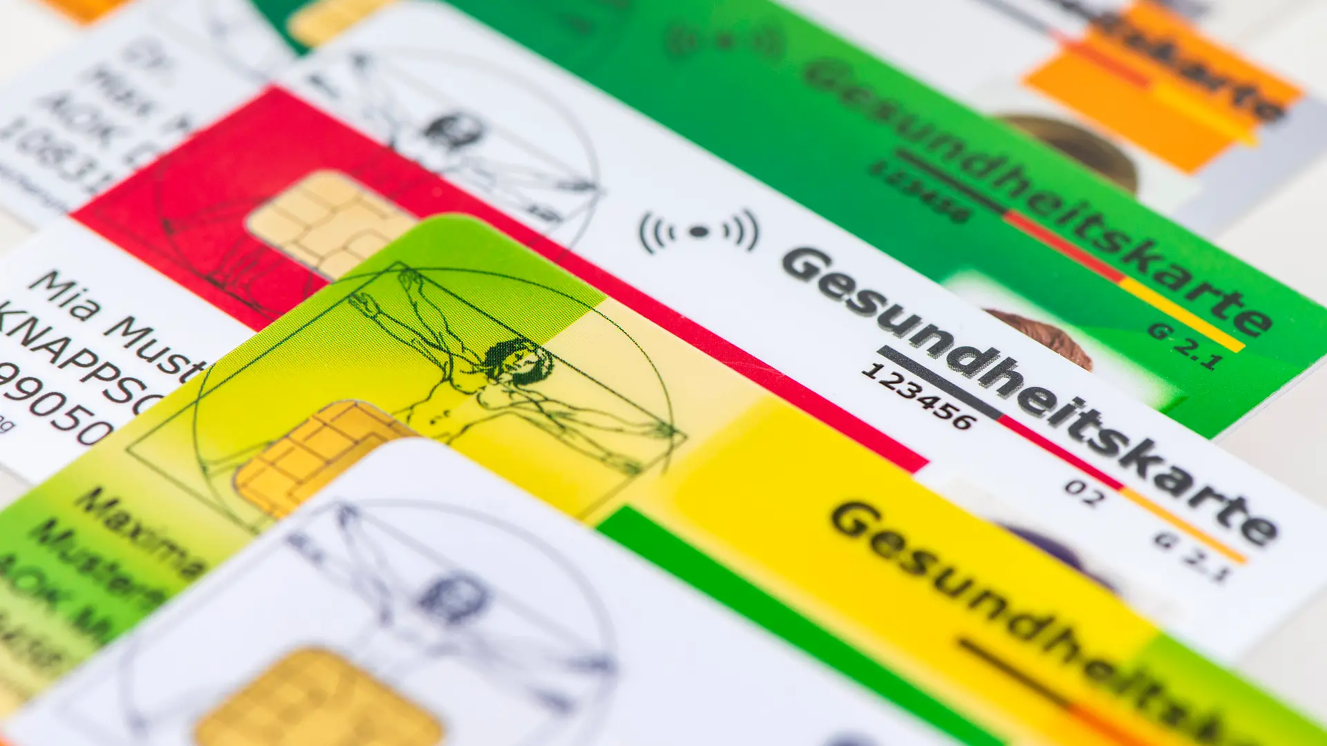 Verschiedene Gesundheitskarten von Krankenversicherungen liegen zusammen als Symbolbild für das Gesundheitssystem basierend auf gesetzlichen Krankenkassen - NUR FÜR REDAKTIONELLE VERWENDUNG -