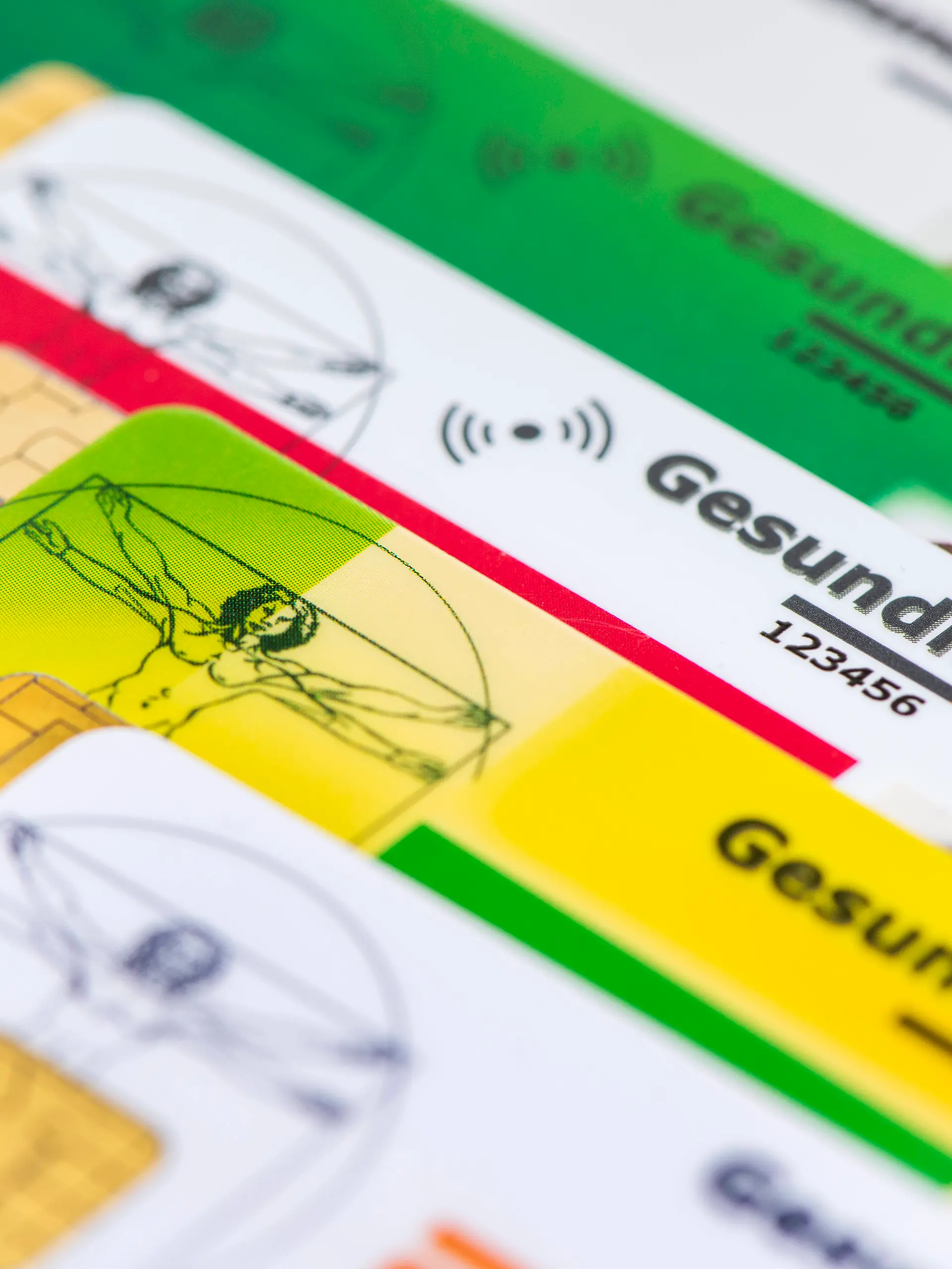 Verschiedene Gesundheitskarten von Krankenversicherungen liegen zusammen als Symbolbild für das Gesundheitssystem basierend auf gesetzlichen Krankenkassen - NUR FÜR REDAKTIONELLE VERWENDUNG -