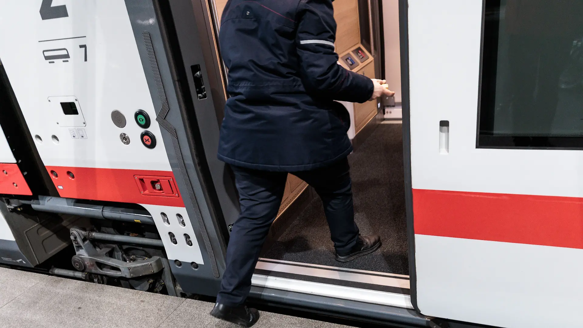 Bahnmitarbeiter steigt in Zug