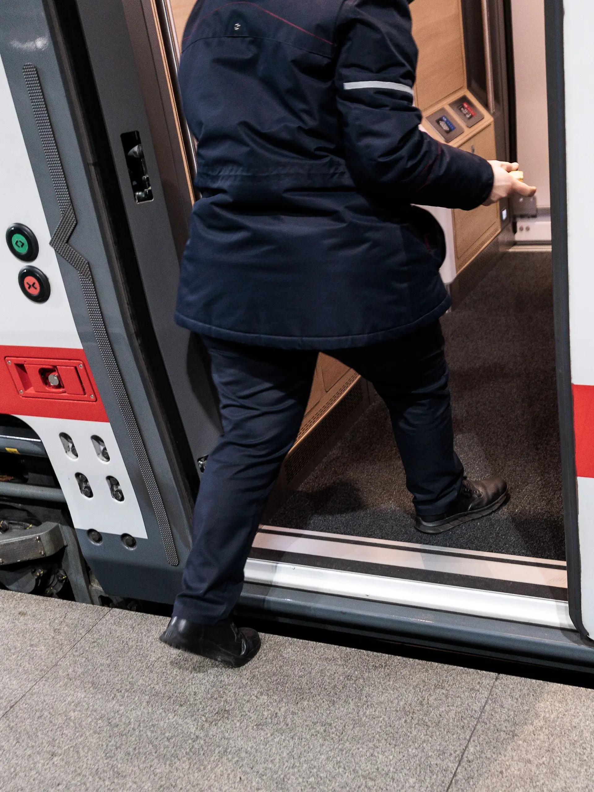 Bahnmitarbeiter steigt in Zug
