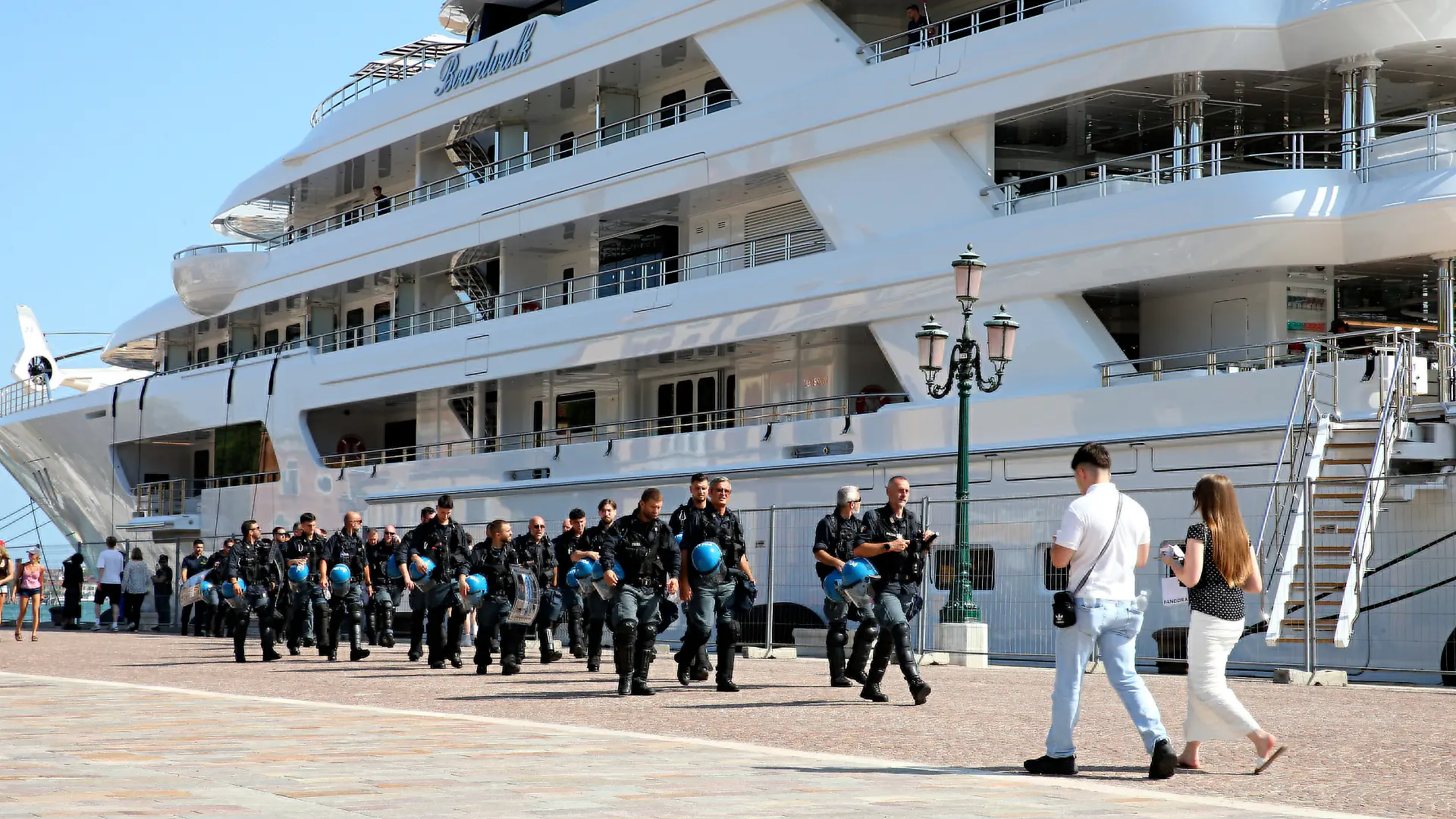 17.07.2026, Italien, Venedig: Einsatzkräfte der Polizei gehen vor der Superyacht «Boardwall» des US-Botschafters Fertitta entlang die im Rahmen der «Freedom 250 Coastal Diplomacy»-Tour des Botschafters im Hafen liegt. Foto: Paola Garbuio/LaPresse via ZUMA Press/dpa +++ dpa-Bildfunk +++