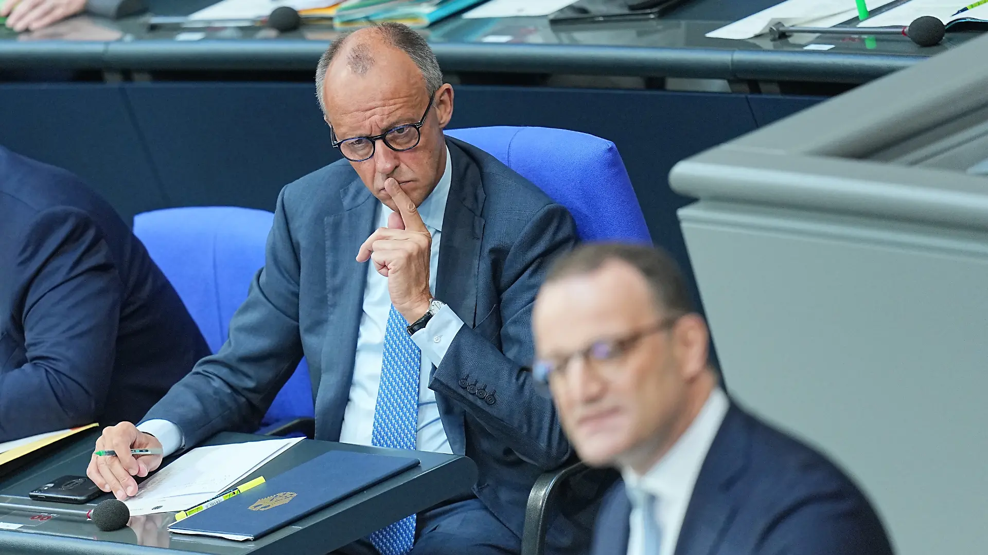Jens Spahn (CDU, r), CDU/CSU-Fraktionsvorsitzender im Bundestag, spricht im Plenarsaal im Bundestag, während Bundeskanzler Friedrich Merz (CDU) zuhört.