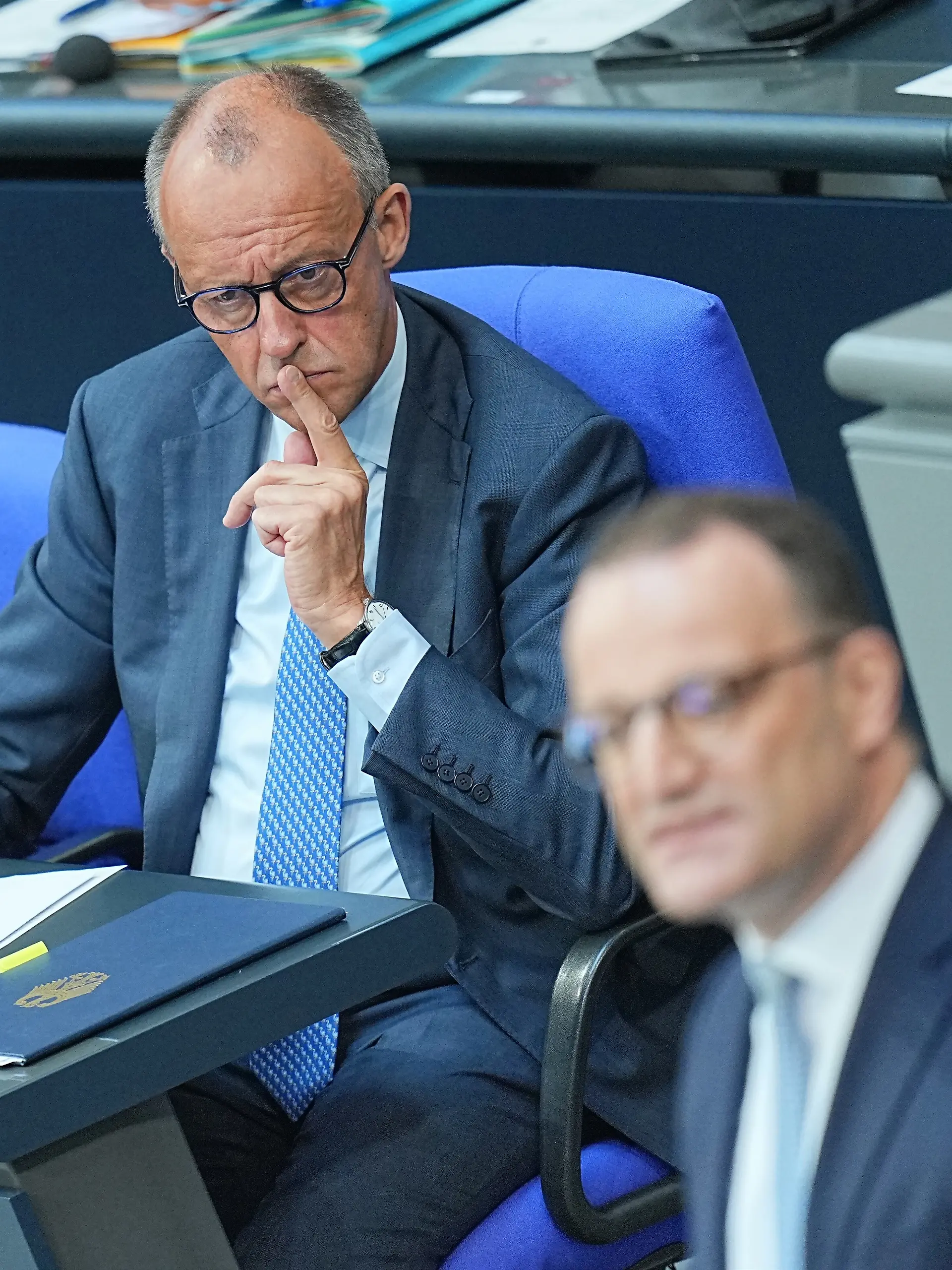 Jens Spahn (CDU, r), CDU/CSU-Fraktionsvorsitzender im Bundestag, spricht im Plenarsaal im Bundestag, während Bundeskanzler Friedrich Merz (CDU) zuhört.
