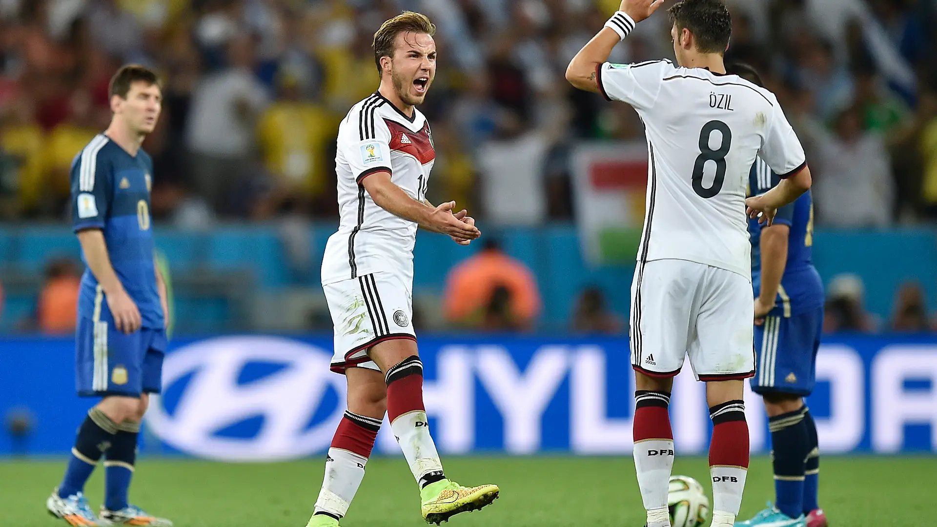 Germany's Mario Goetze, center, celebrates with Mesut Ozil (8) in front of Argentina's Lionel Messi, left, after Goetze scored the opening goal during the World Cup final soccer match between Germany and Argentina at the Maracana Stadium in Rio de Janeiro, Brazil, Sunday, July 13, 2014. (AP Photo/Martin Meissner)