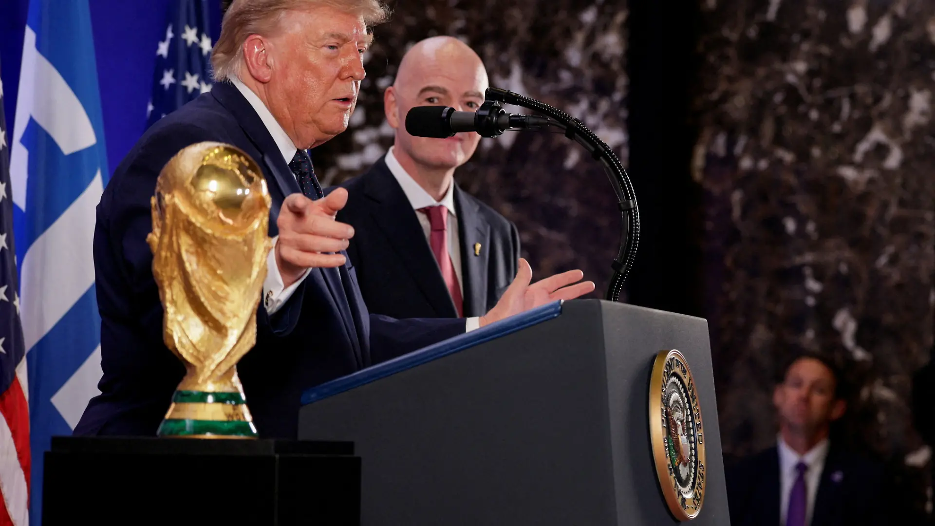 U.S. President Donald Trump, flanked by FIFA President Gianni Infantino, gestures while speaking next to FIFA World Cup Trophy, as they attend a FIFA reception at Trump Tower in New York City, U.S., July 17, 2026. REUTERS/Evan Vucci TPX IMAGES OF THE DAY