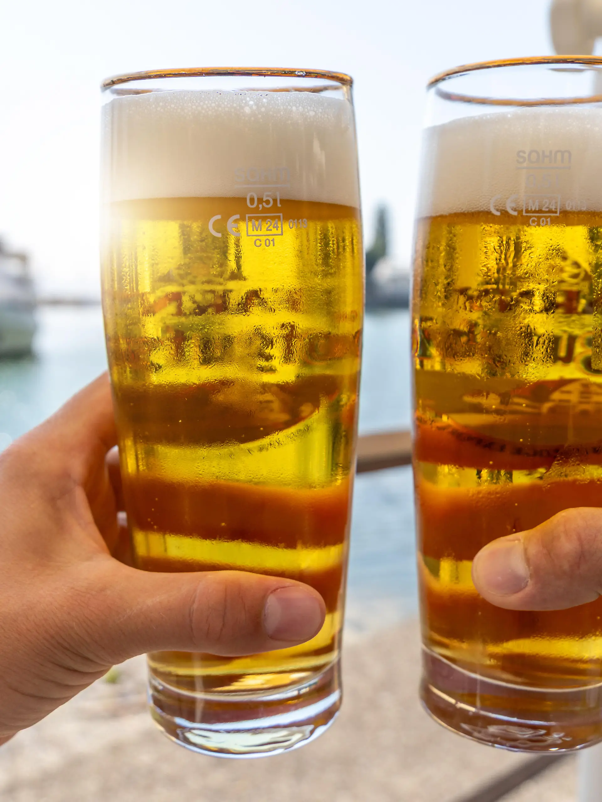 Prost am Wasser im Urlaub zwei kühle Biergläser im Sommerlicht