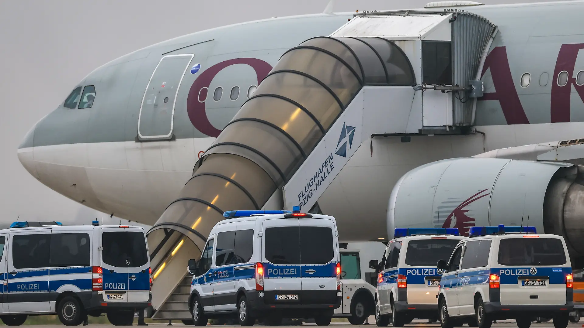 Polizeifahrzeuge stehen vor einem Flugzeug der Qatar Airways auf dem Flughafen Leipzig/Halle. Wie eine Sprecherin des Bundesinnenministeriums bestätigte, startet das Flugzeug vom Flughafen in Leipzig aus mit 81 Menschen an Bord, um diese in ihr Herkunftsland Afghanistan zurückzubringen. Deutschland schiebt damit zum zweiten Mal seit der Machtübernahme durch die Taliban im August 2021 afghanische Staatsangehörige in ihr Herkunftsland ab.