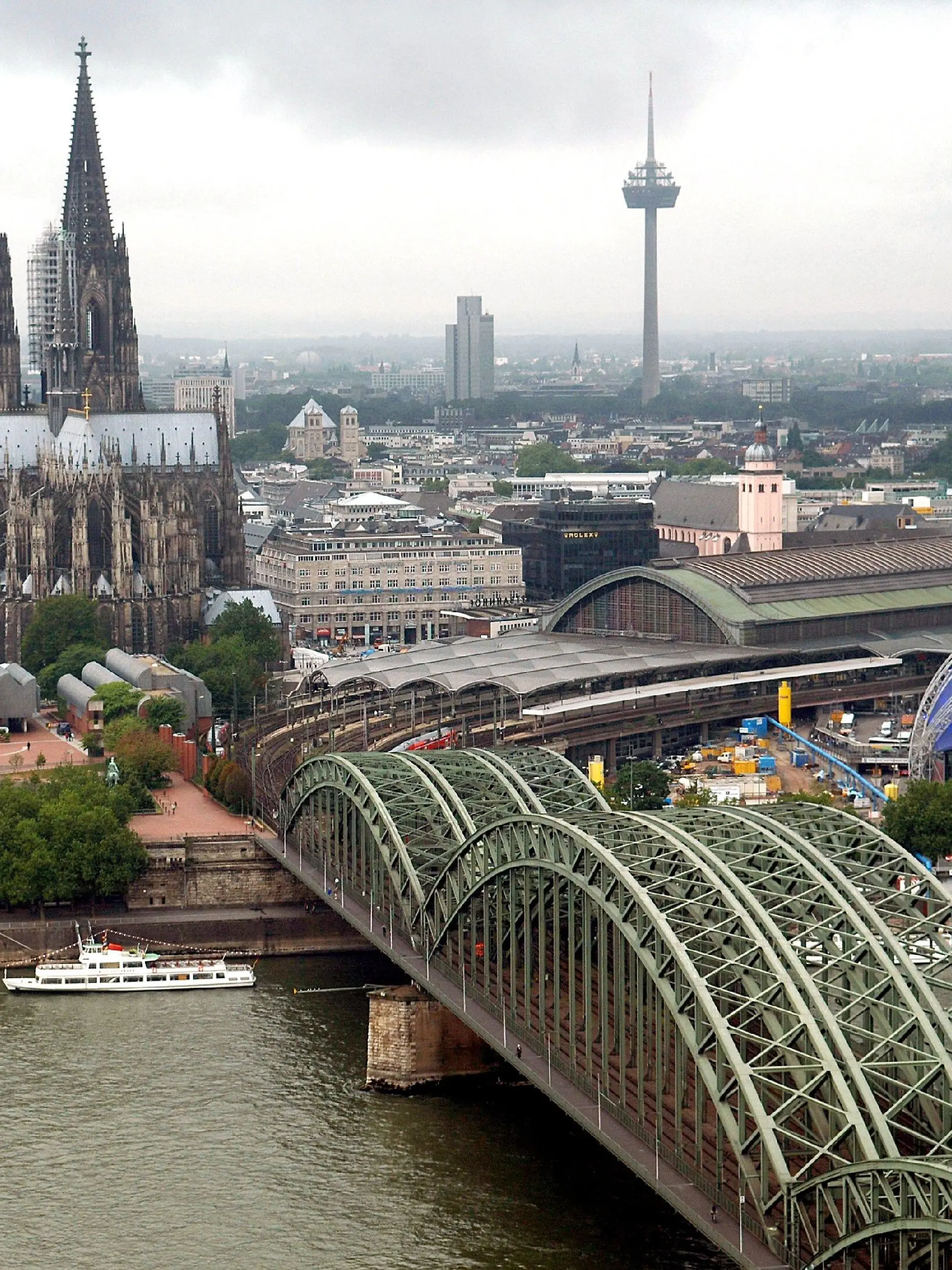 ARCHIV - Über den Rhein führt die Hohenzollernbrücke - vorbei am Dom - zum Hauptbahnhof in Köln. (Archivfoto vom 26.07.2005). Die Anwohner des Rheins und seiner Zuflüsse bis zur Stadt Köln schnupfen einer Wasseranalyse zufolge rund neun Tonnen Kokain im Jahr. Das schließen Wissenschaftler des Nürnberger Instituts für Biomedizinische und Pharmazeutische Forschung aus der Messung eines Kokain-Abbauprodukts im größten deutschen Fluss. Auf seinem Weg bis Köln nehme der Rhein das Abwasser von fast 40 Millionen Menschen auf, erläuterte Institutschef Prof. Sörgel am Mittwoch (22.11.2006). Für ganz Deutschland ergebe sich aus den Messwerten ein grob geschätzter Jahresverbrauch von rund 20 Tonnen Kokain. Foto: Oliver Berg dpa/lnw (zu dpa 0383 vom 22.11.2006) +++(c) dpa - Bildfunk+++