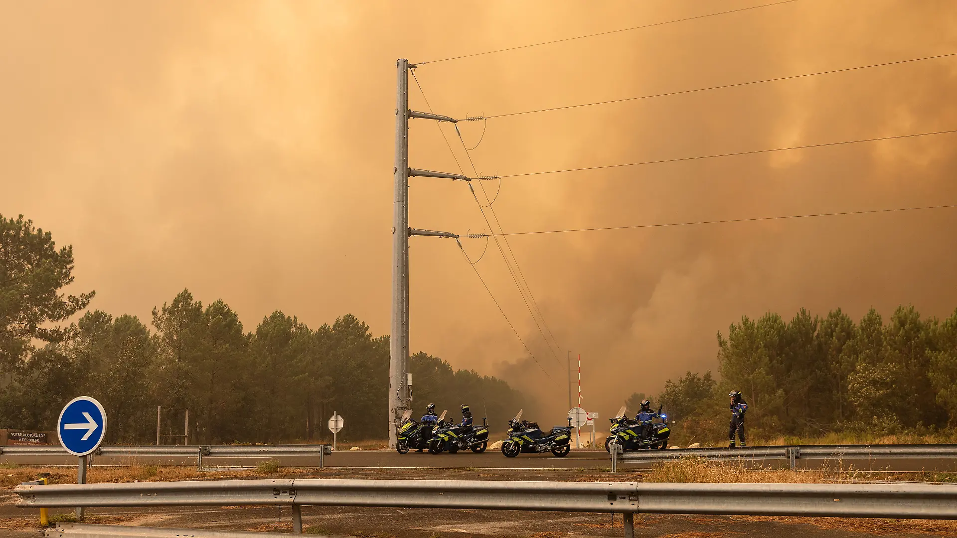 Fire spreading toward a road near Lège-Cap-Ferret on July 24, 2026. Firefighters are forced to remove metal safety barriers to create a passage for their trucks. Firefighters work to extinguish buildings and homes engulfed in flames in Le Porge, southwestern France, on July 24, 2026. Emergency crews were deployed to combat the fire, protect surrounding properties, and prevent the blaze from spreading as operations continued.//GARCIASOPHIE_sipa.13229/Credit:Sophie Garcia/SIPA/2607250506