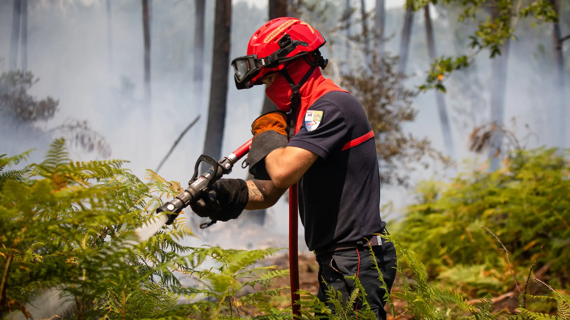 Firefighters are attempting to extinguish fire in the forest in Le Porge on July 24, 2026. Firefighters work to extinguish buildings and homes engulfed in flames in Le Porge, southwestern France, on July 24, 2026. Emergency crews were deployed to combat the fire, protect surrounding properties, and prevent the blaze from spreading as operations continued.//GARCIASOPHIE_sipa.13187/Credit:Sophie Garcia/SIPA/2607250503