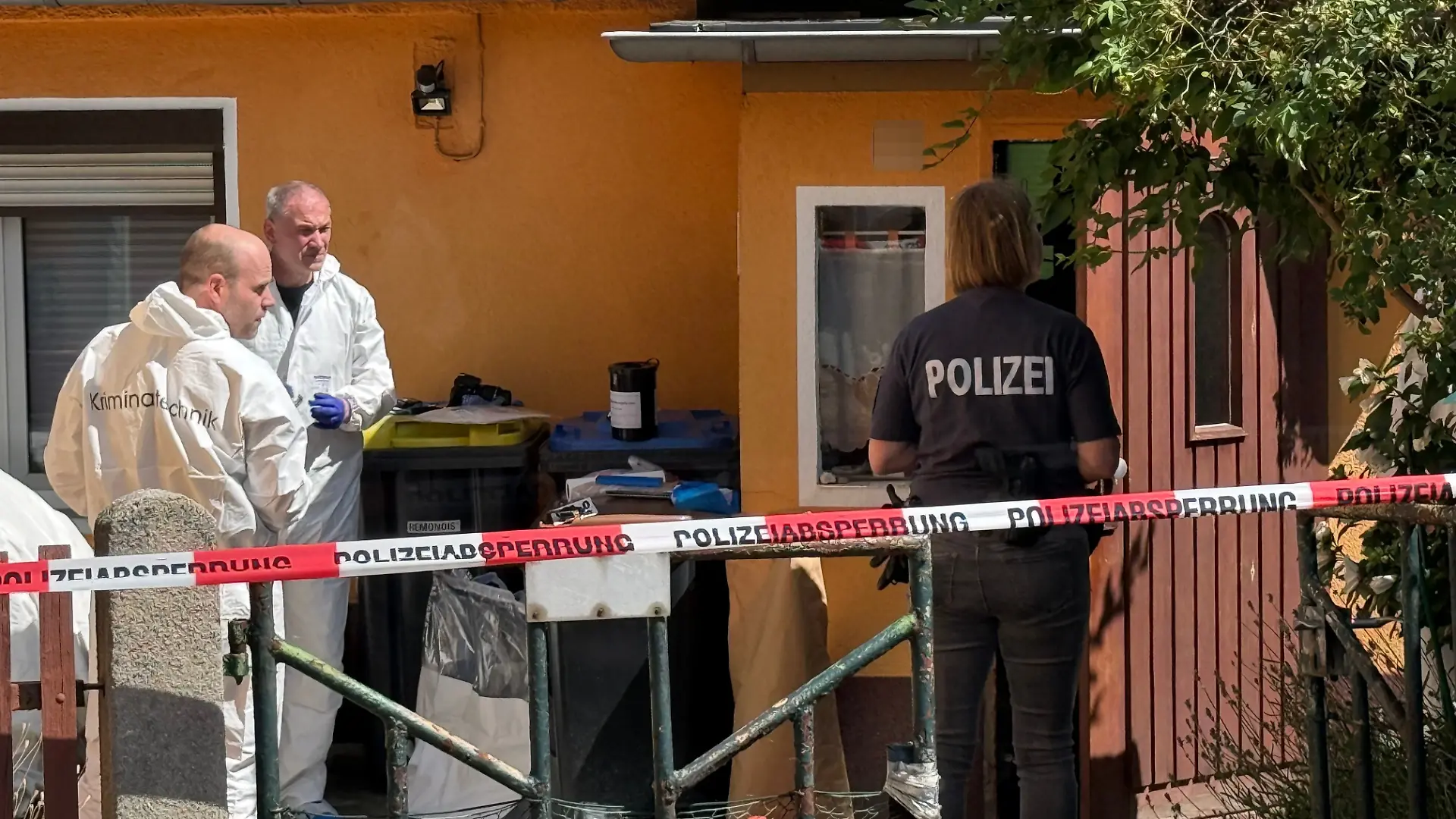 Mitarbeiter der Kriminaltechnik und Polizei stehen vor einem Haus. Ermittler fanden in der Stadt im Landkreis Oberspreewald-Lausitz die Leichen eines 57 Jahre alten Mannes und einer 45-jährigen Frau. Eine schwer verletzte Person sei ins Krankenhaus gekommen.