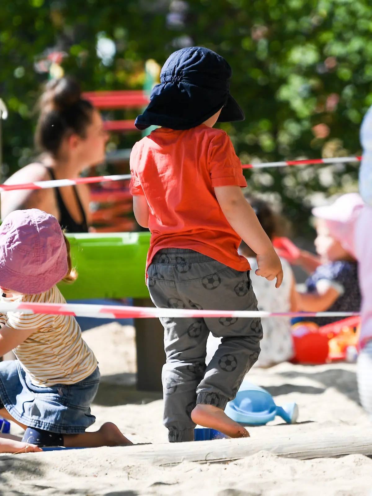 ARCHIV - 02.06.2020, Offenbach/Main: Kinder einer Krippen-Gruppe spielen auf dem Spielplatz der Kita, auf dem Absperrbänder den Abstand zu den Gruppen markieren.    (zu dpa «Im Saarland dürfen wieder mehr Kinder in die Kitas») Foto: Arne Dedert/dpa +++ dpa-Bildfunk +++