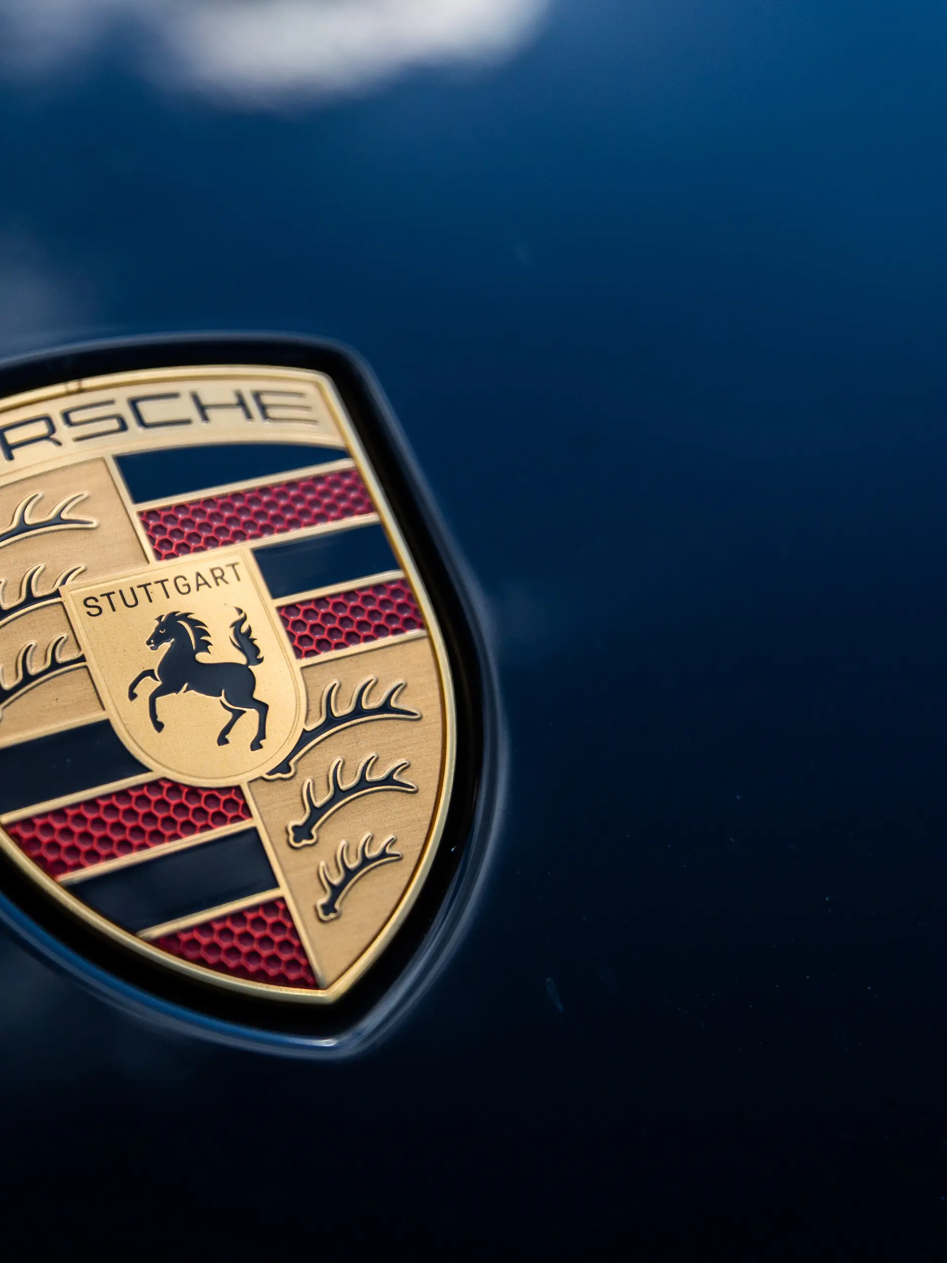 Das Porsche Logo ist auf einem Porsche-Fahrzeug zu sehen.