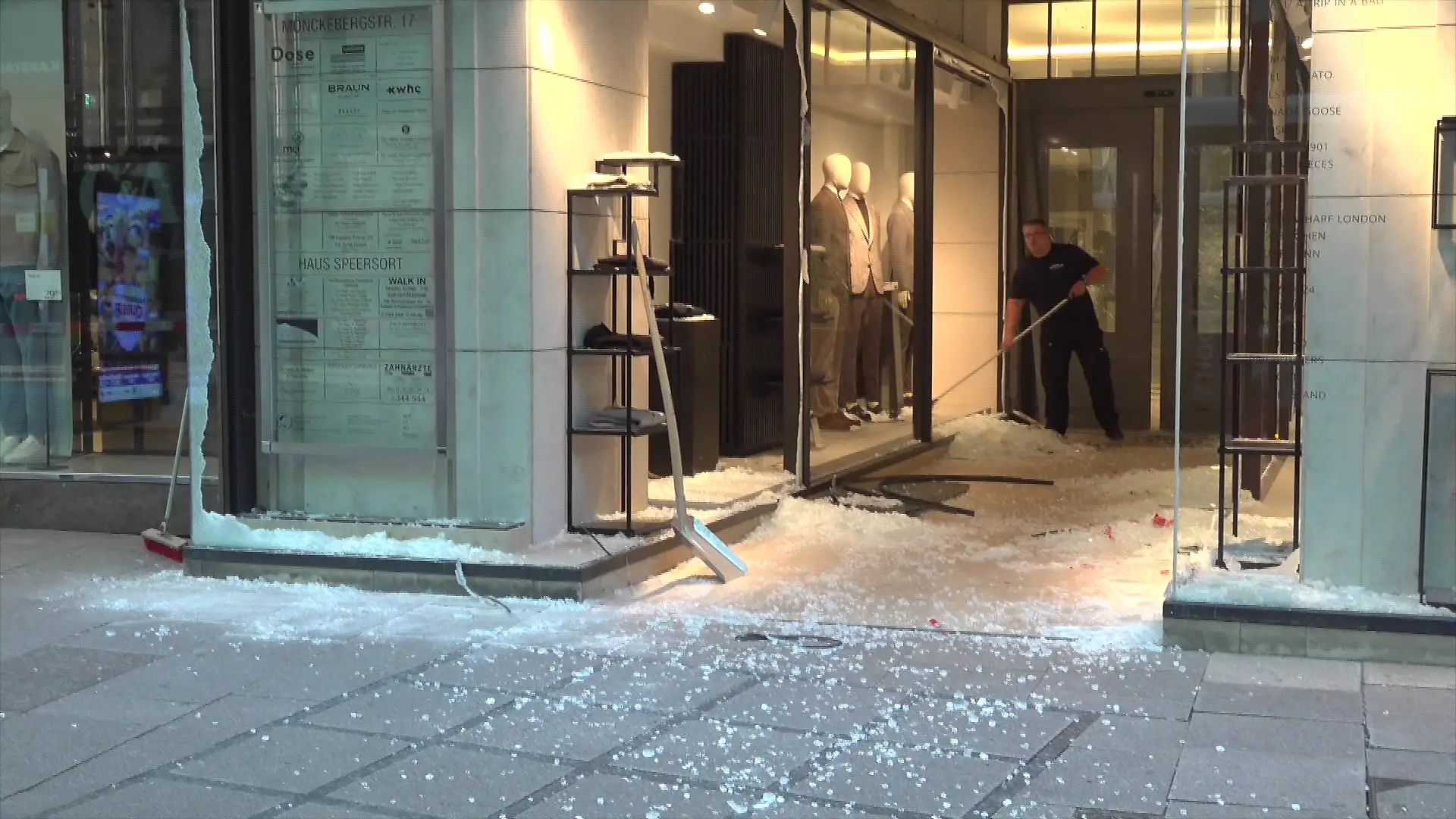 Nach der Explosion fegt ein Mitarbeiter die Glasscherben vor dem beschädigten Schaufenster zusammen. 