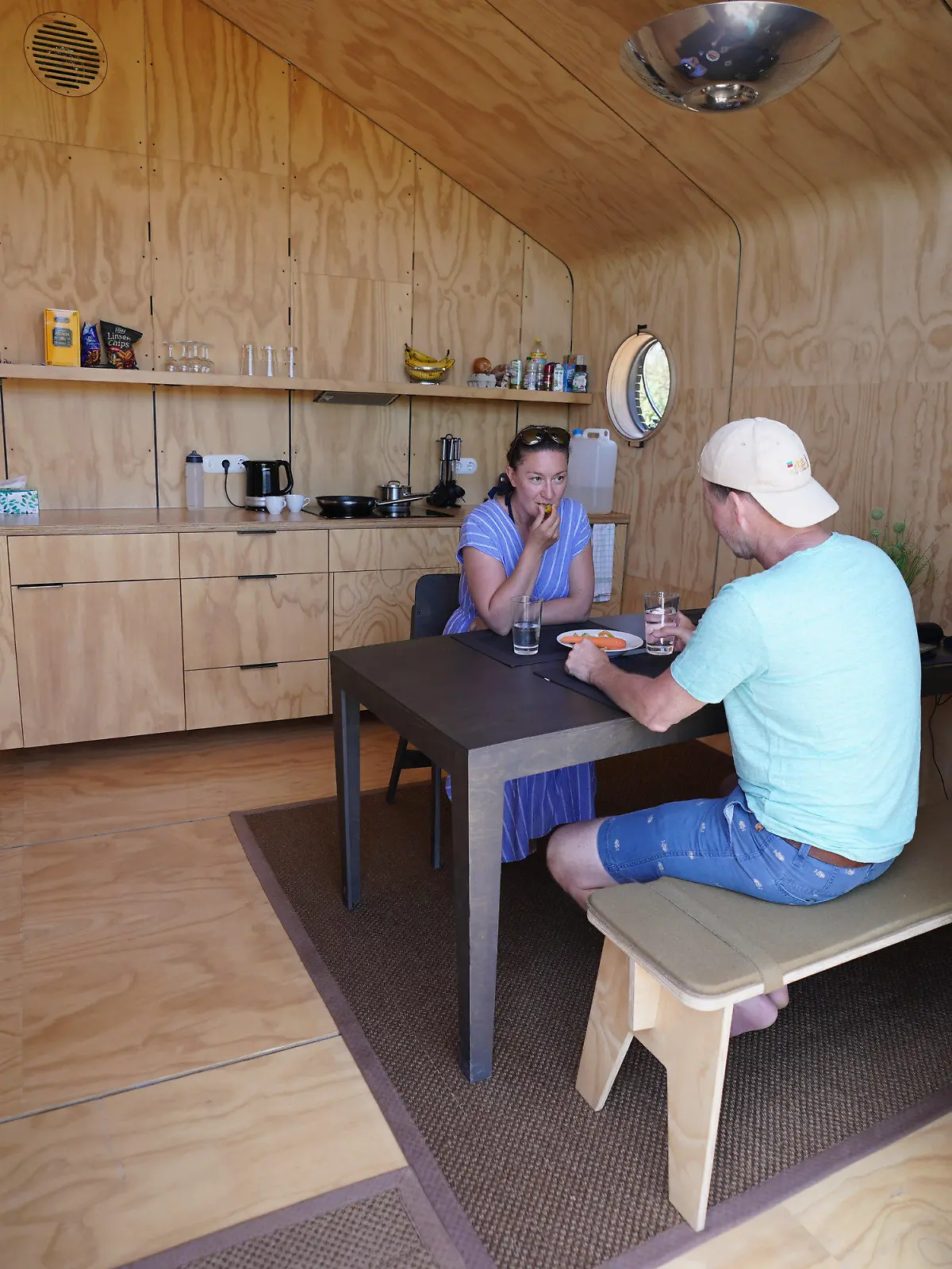 16.06.2021, Schleswig-Holstein, Helgoland: Monique Eichhorn und Sebastian Ebeling, Urlauber aus Berlin, sitzen in einem sogenannten Wikkelhouse auf der Helgoländer Düne. Die beiden sogenannten Wikkelhouses aus einer Manufaktur in Amsterdam sind nach Angaben des Helgoland Tourismus-Services für diese Saison ausgebucht. Auch im kommenden Jahr sind die Tiny Houses, die nur online und wochenweise gebucht werden können, bereits belegt. Die kleinen Häuser, deren Wände im Kern aus 24 miteinander verwickelter Schichten Pappe bestehen, sind komplett ausgestattet - es gibt aber kein Wasser und keine Toilette. (zu dpa «Gefragte Pappe: Helgoland möchte mehr Wikkelhouses») Foto: Marcus Brandt/dpa +++ dpa-Bildfunk +++