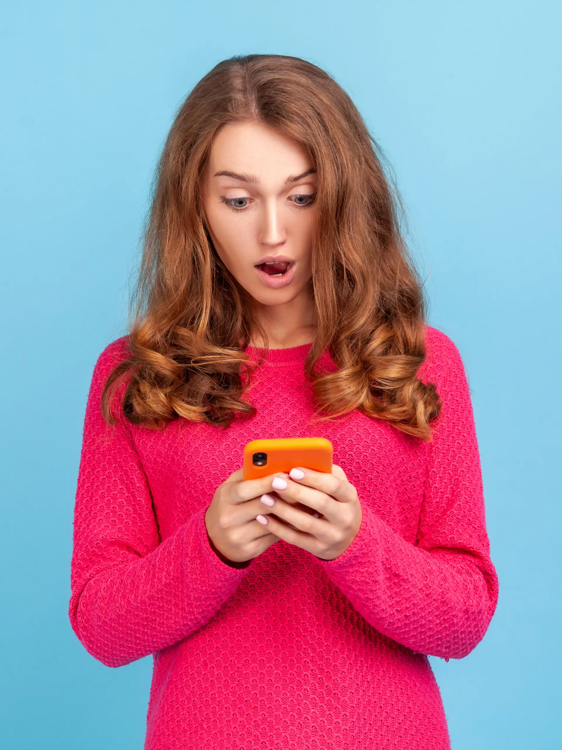 Eine Frau guckt erschrocken auf ihr Handy