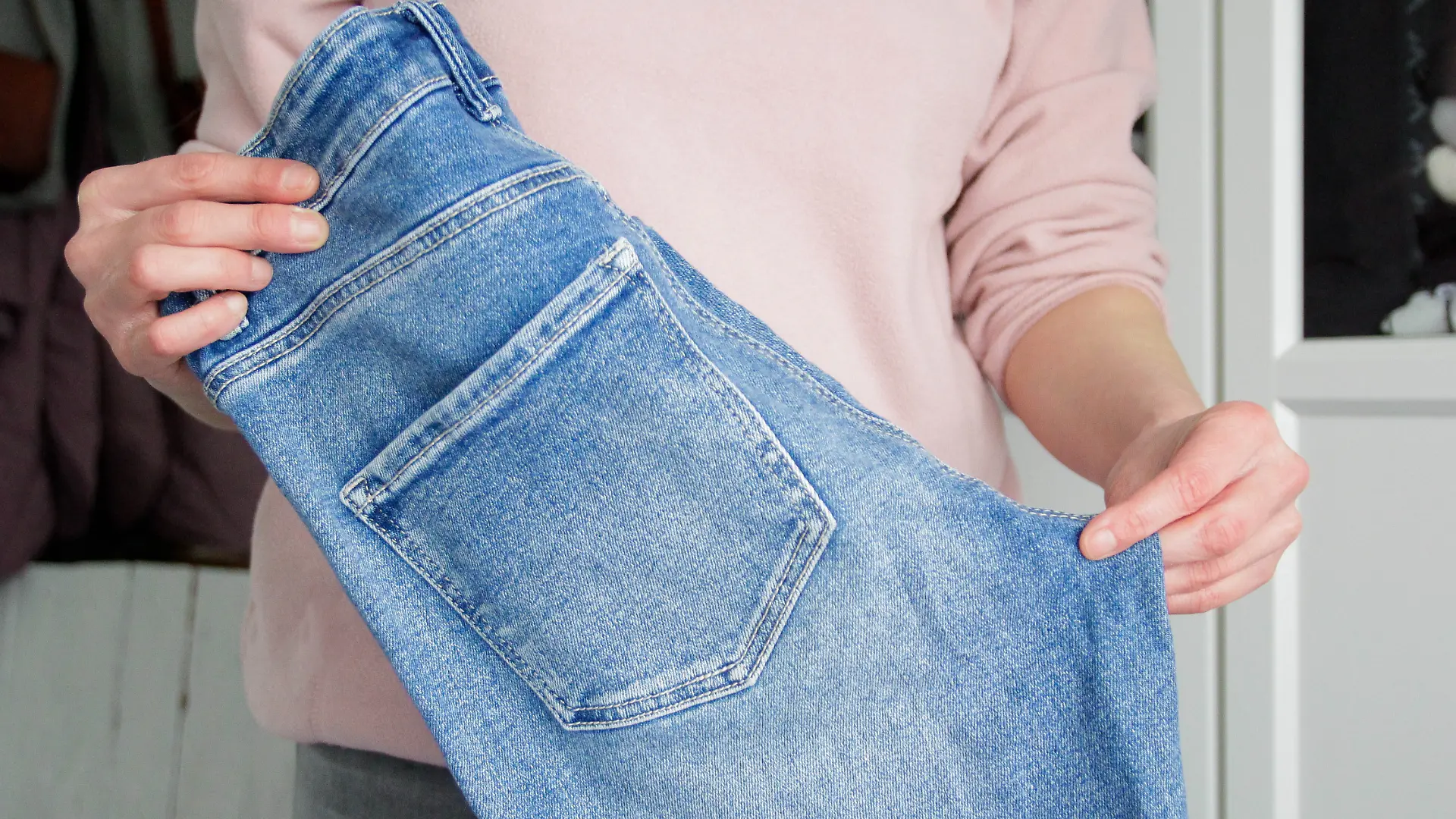 Frau hat Jeans in der Hand