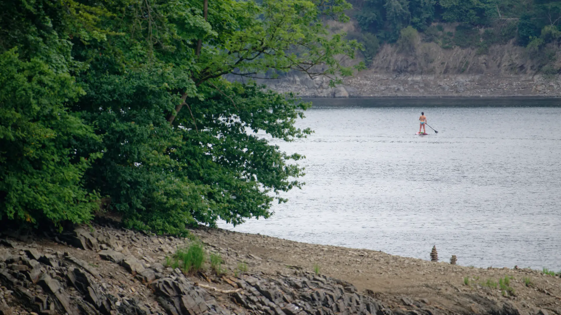 Eine Frau fährt auf einem Stand up Paddle Board auf dem Möhnesee.