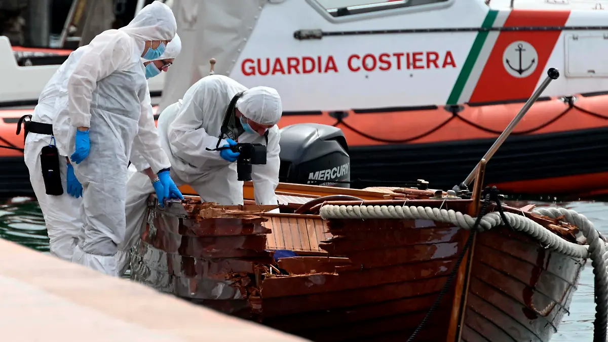 ARCHIV - 20.06.2021, Italien, Salo: Italienische Forensiker begutachten den Schaden an einem Boot. Die italienische Justiz hat im Fall des tödlichen Bootsunglücks auf dem Gardasee in Norditalien einen europäischen Haftbefehl gegen einen der zwei deutschen Verdächtigen erlassen. (zu dpa «Tödlicher Bootsunfall auf Gardasee: Haftbefehl gegen Deutschen») Foto: Gabriele Strada/AP/dpa +++ dpa-Bildfunk +++