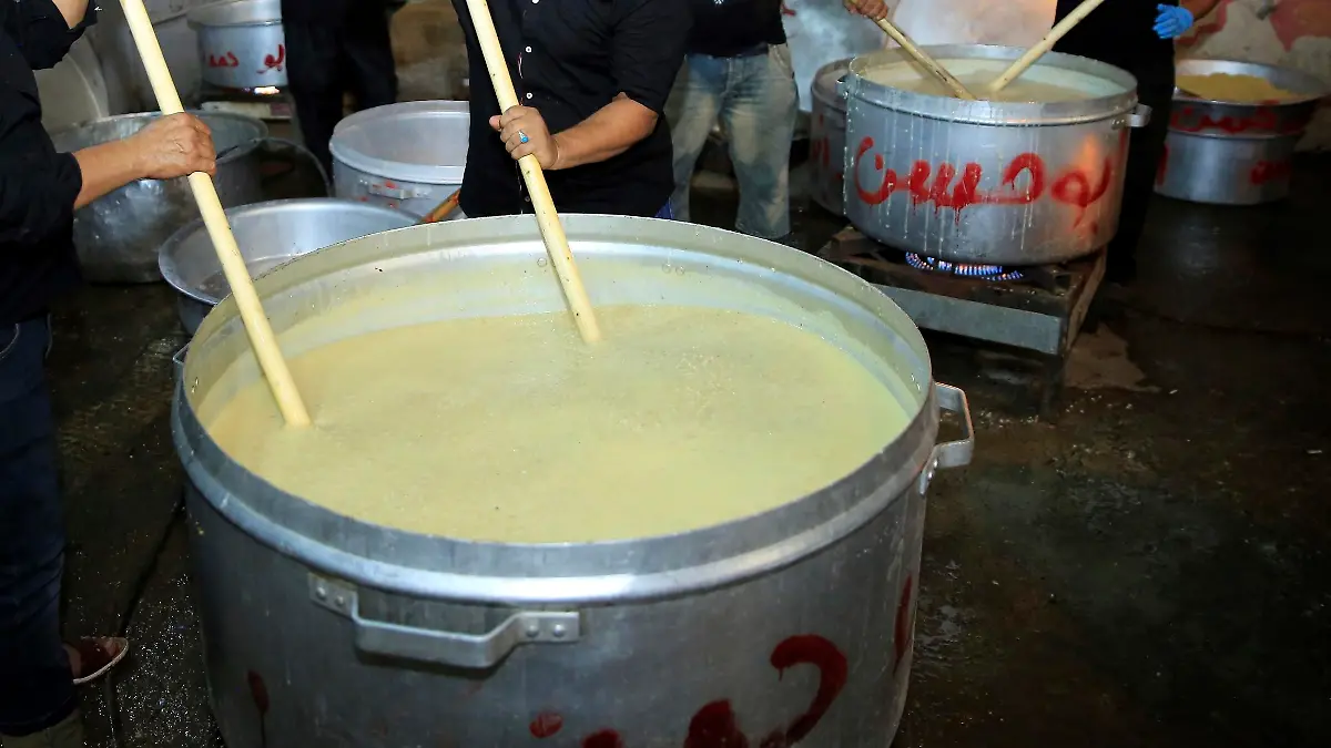 BAGHDAD, IRAQ - SEPTEMBER 19: People cook ashura (Noah's Pudding), as part of the holy month of Muharram commemorations in Baghdad, Iraq on September 19, 2018. Ashure or Noah's Pudding dessert porridge made of a mixture consisting of grains, fruits, dried fruits and nuts. Ashura is the tenth day of Muharram in the Islamic calendar. Muslims mark Ashura each year, the tenth day of the first Islamic month of Muharram, to commemorate the martyrdom of Prophet Muhammad's grandson Imam al-Hussein (Husayn Ibn Ali) and his accompanies, who were killed in the battle of Karbala in modern day Iraq in 680 AD. Haydar Karaalp / Anadolu Agency