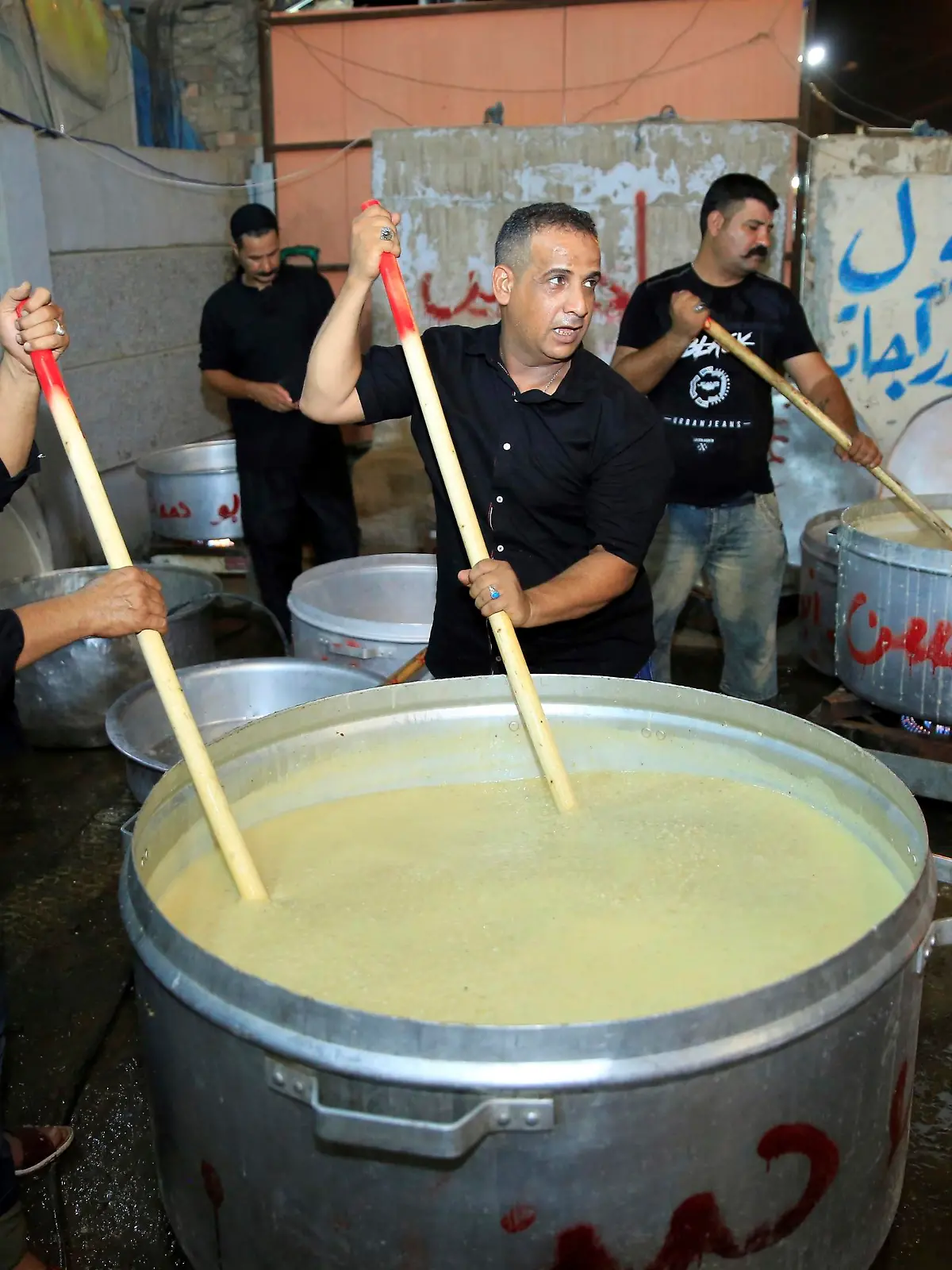 BAGHDAD, IRAQ - SEPTEMBER 19: People cook ashura (Noah's Pudding), as part of the holy month of Muharram commemorations in Baghdad, Iraq on September 19, 2018. Ashure or Noah's Pudding dessert porridge made of a mixture consisting of grains, fruits, dried fruits and nuts. Ashura is the tenth day of Muharram in the Islamic calendar. Muslims mark Ashura each year, the tenth day of the first Islamic month of Muharram, to commemorate the martyrdom of Prophet Muhammad's grandson Imam al-Hussein (Husayn Ibn Ali) and his accompanies, who were killed in the battle of Karbala in modern day Iraq in 680 AD. Haydar Karaalp / Anadolu Agency