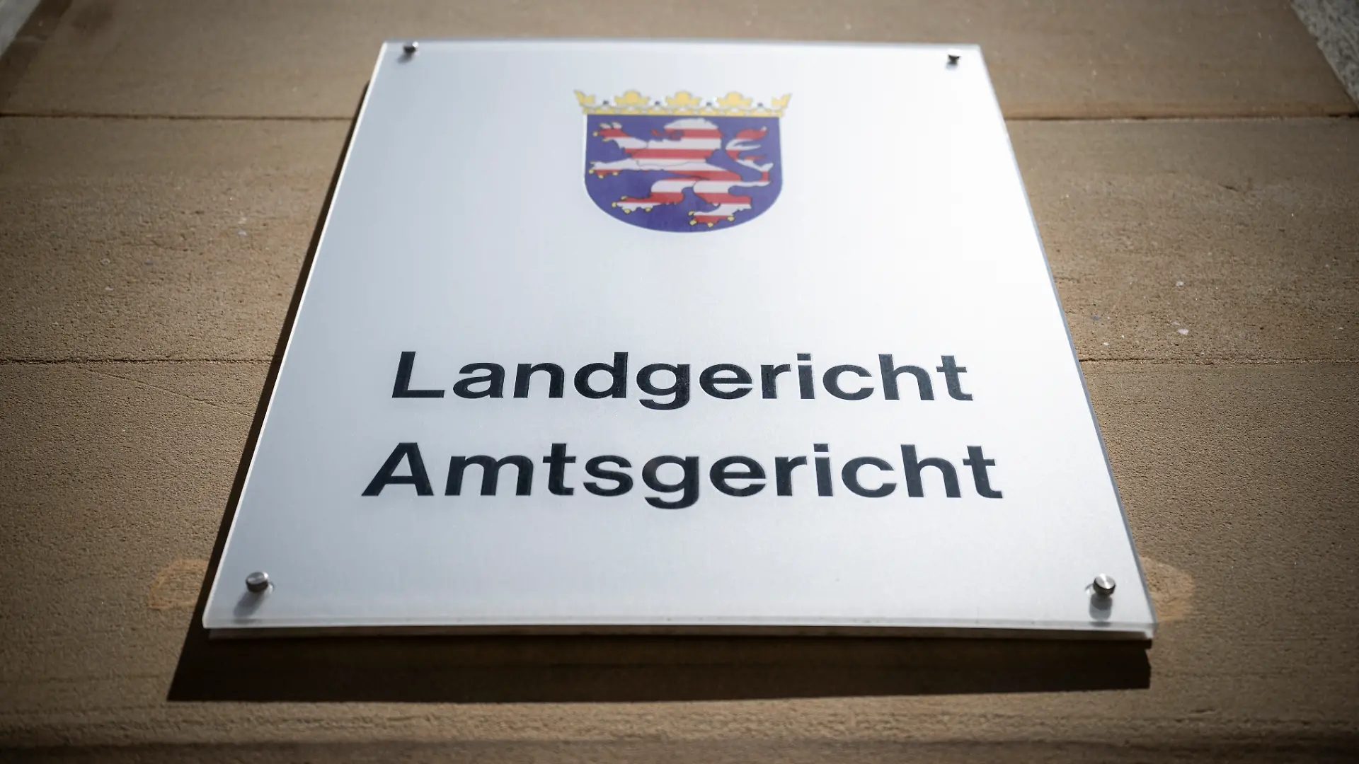 Blick auf ein Schild mit dem Landeswappen von Hessen und der Aufschrift «Landgericht - Amtsgericht».