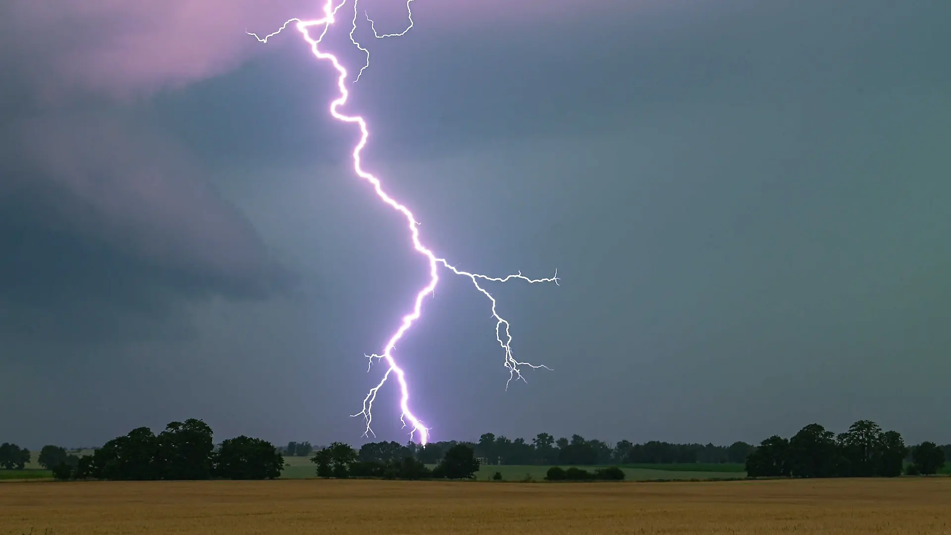 Ein Blitz leuchtet über einer Landschaft auf