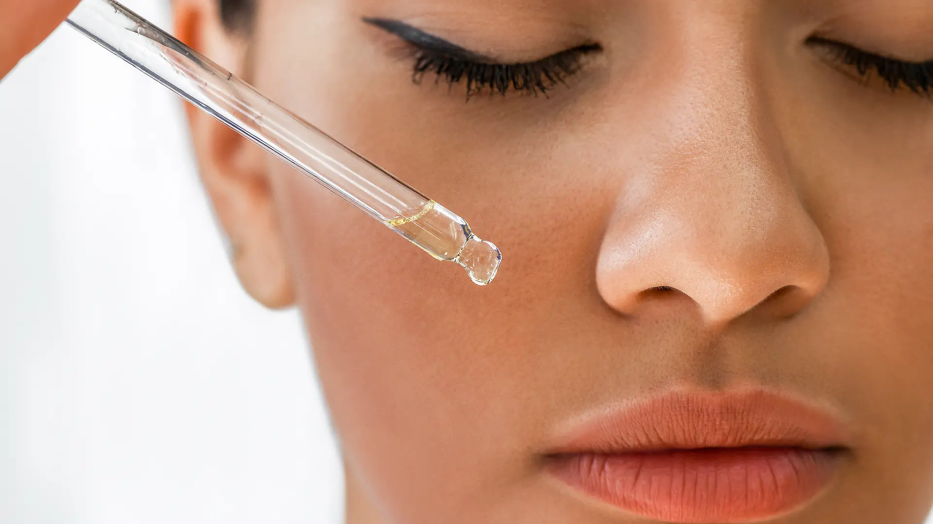 Close-Up einer Frau die Tanning Drops mit Pipette aufträgt 