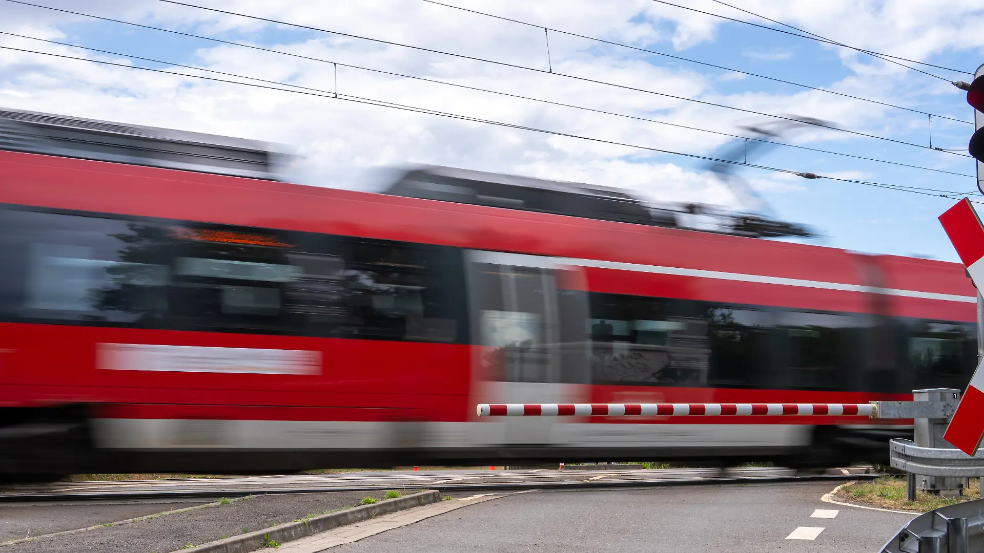 Regionalbahn fährt über einen Bahnübergang