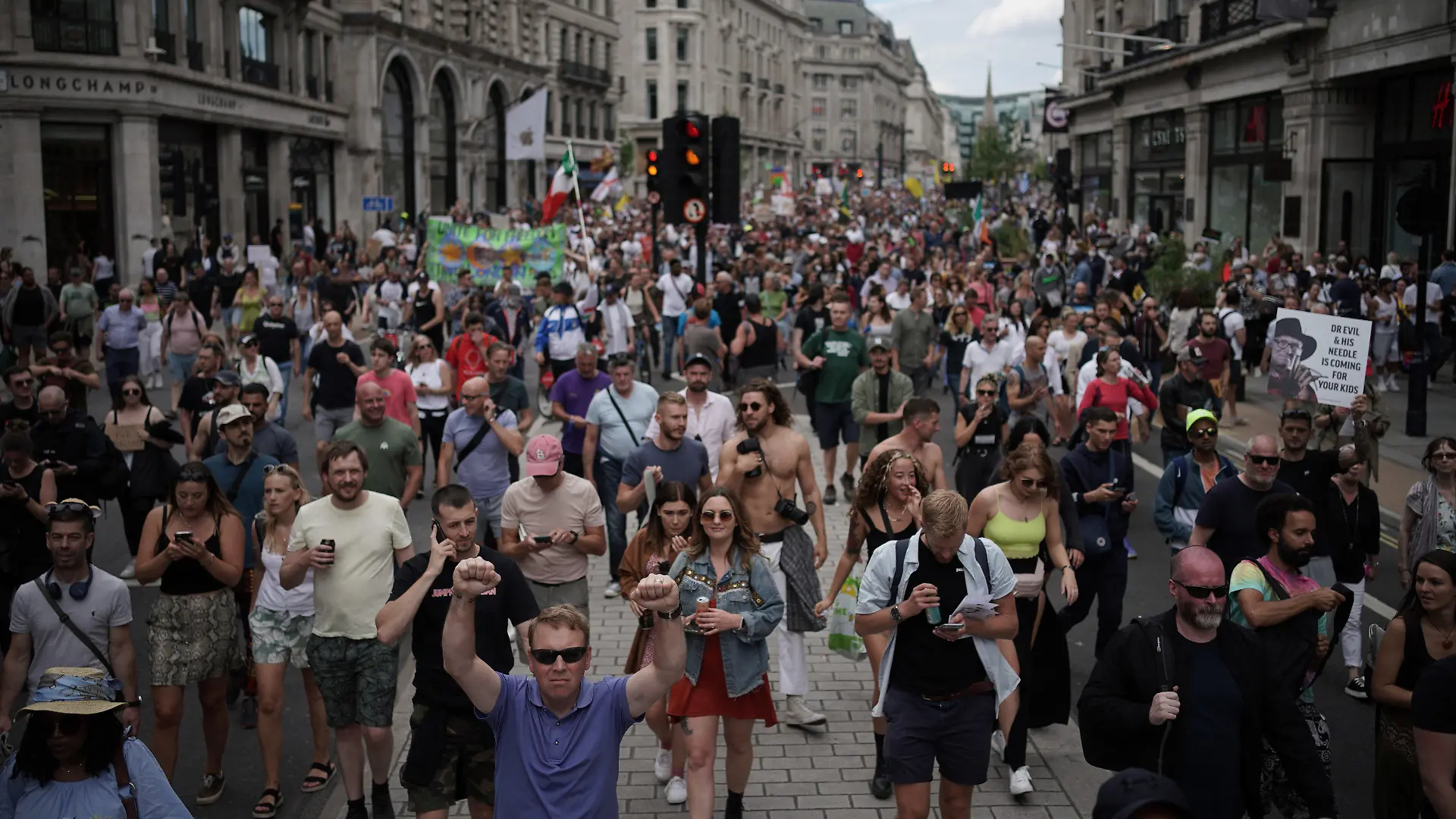 26.06.2021, Großbritannien, London: Demonstranten gehen bei einem Protest für ein Ende der Maßnahmen zur Eindämmung der Corona-Pandemie und des Lockdowns die Regents Street entlang. Foto: Aaron Chown/PA Wire/dpa +++ dpa-Bildfunk +++