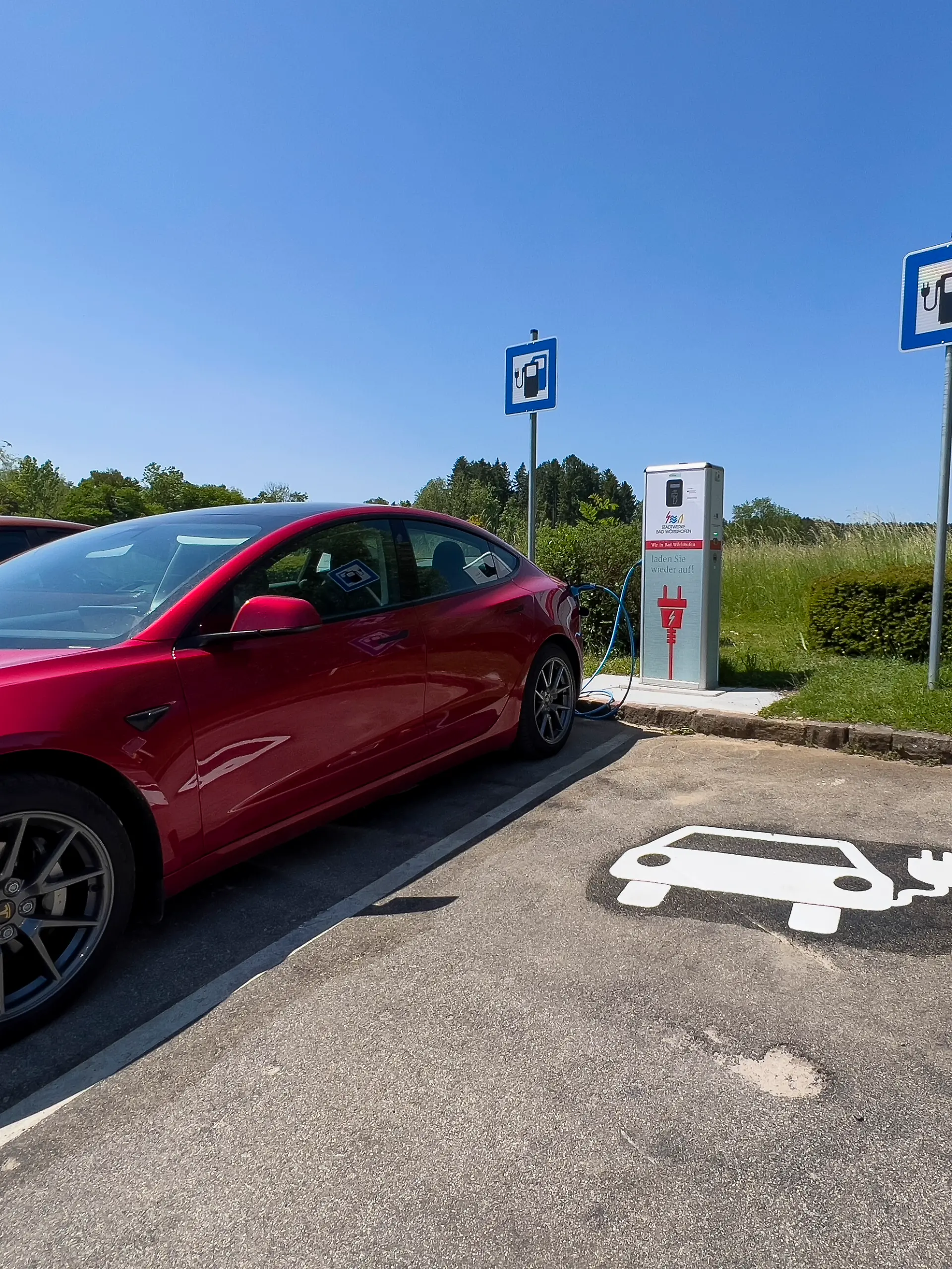 08.06.2023, Bad Woerishofen im Allgaeu, Ladesaeule fuer E-Autos im Wohngebiet. Ein Tesla Model 3 laedt gerade seinen Akku voll.