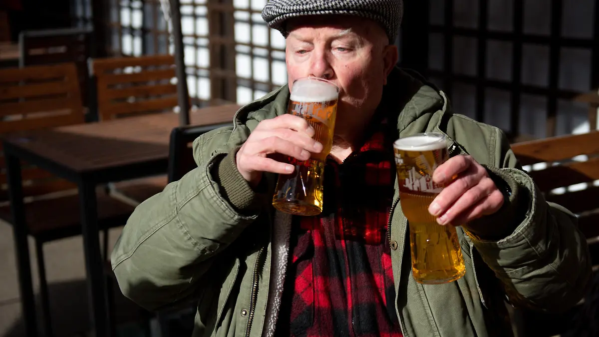12.04.2021, Großbritannien, Birmingham: John Witts trinkt bei der Wiedereröffnung des Pubs «Figure of Eight» zwei Bier. Im größten Landesteil Großbritanniens werden die Maßnahmen zur Eindämmung der Coronavirus-Pandemie weiter gelockert. In England dürfen jetzt unter anderem Läden, Friseure und auch die Außengastronomie wieder aufmachen. Foto: Jacob King/PA Wire/dpa +++ dpa-Bildfunk +++