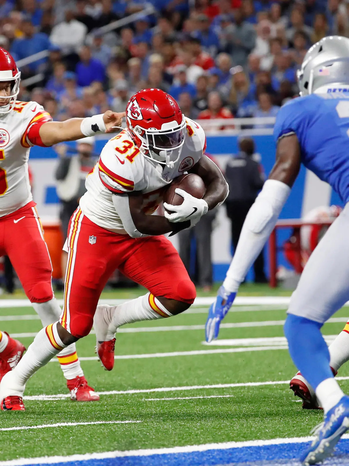 Kansas City Chiefs quarterback Patrick Mahomes (15) hands off to running back Darrel Williams (31) for a 1-yard touchdown rush during the second half of an NFL football game against the Detroit Lions, Sunday, Sept. 29, 2019, in Detroit. (AP Photo/Rick Osentoski)