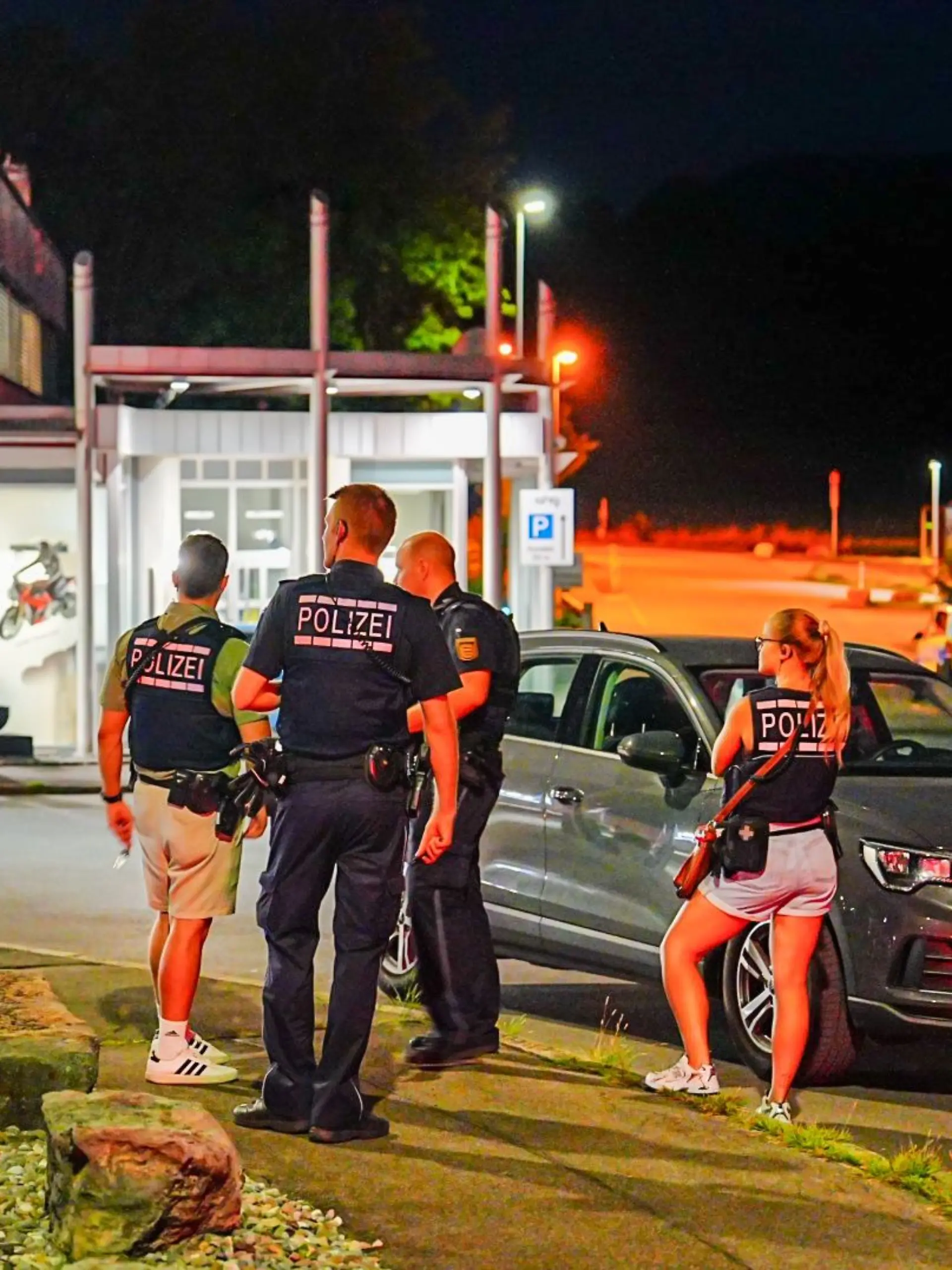 Einsatzkräfte der Polizei stehen am Tatort. Ein maskierter Täter war vor ein fahrendes Auto gesprungen und hatte auf den Wagen geschossen, der Fahrer wurde durch Splitter eines beschädigten Verkleidungsteils oberflächlich verletzt. 