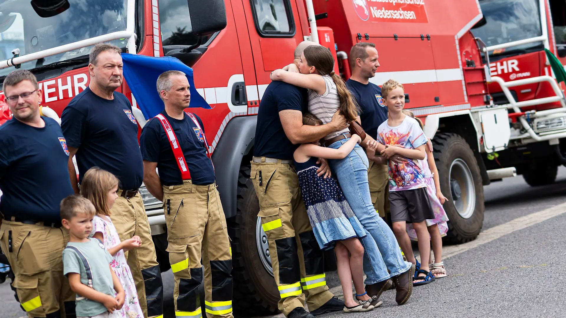 06.08.2026, Niedersachsen, Celle: Niedersächsische Einsatzkräfte werden nach ihrer Rückkehr vom Waldbrandeinsatz in Spanien im Niedersächsischen Landesamt für Brand- und Katastrophenschutz von Angehörigen empfangen. Aus Niedersachsen hatten neun Feuerwehrleute an dem Waldbrandeinsatz teilgenommen. Foto: Michael Matthey/dpa +++ dpa-Bildfunk +++