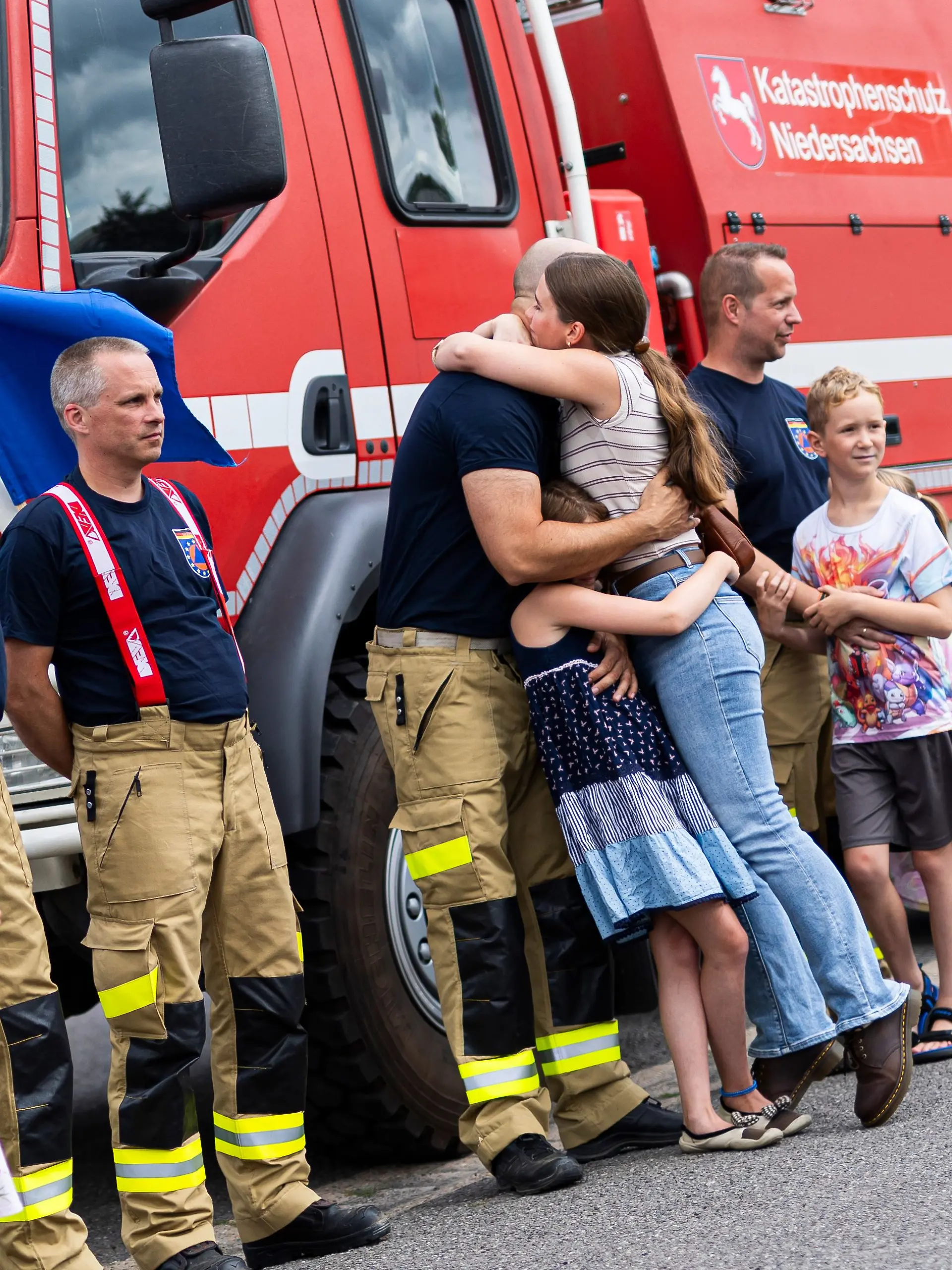 06.08.2026, Niedersachsen, Celle: Niedersächsische Einsatzkräfte werden nach ihrer Rückkehr vom Waldbrandeinsatz in Spanien im Niedersächsischen Landesamt für Brand- und Katastrophenschutz von Angehörigen empfangen. Aus Niedersachsen hatten neun Feuerwehrleute an dem Waldbrandeinsatz teilgenommen. Foto: Michael Matthey/dpa +++ dpa-Bildfunk +++