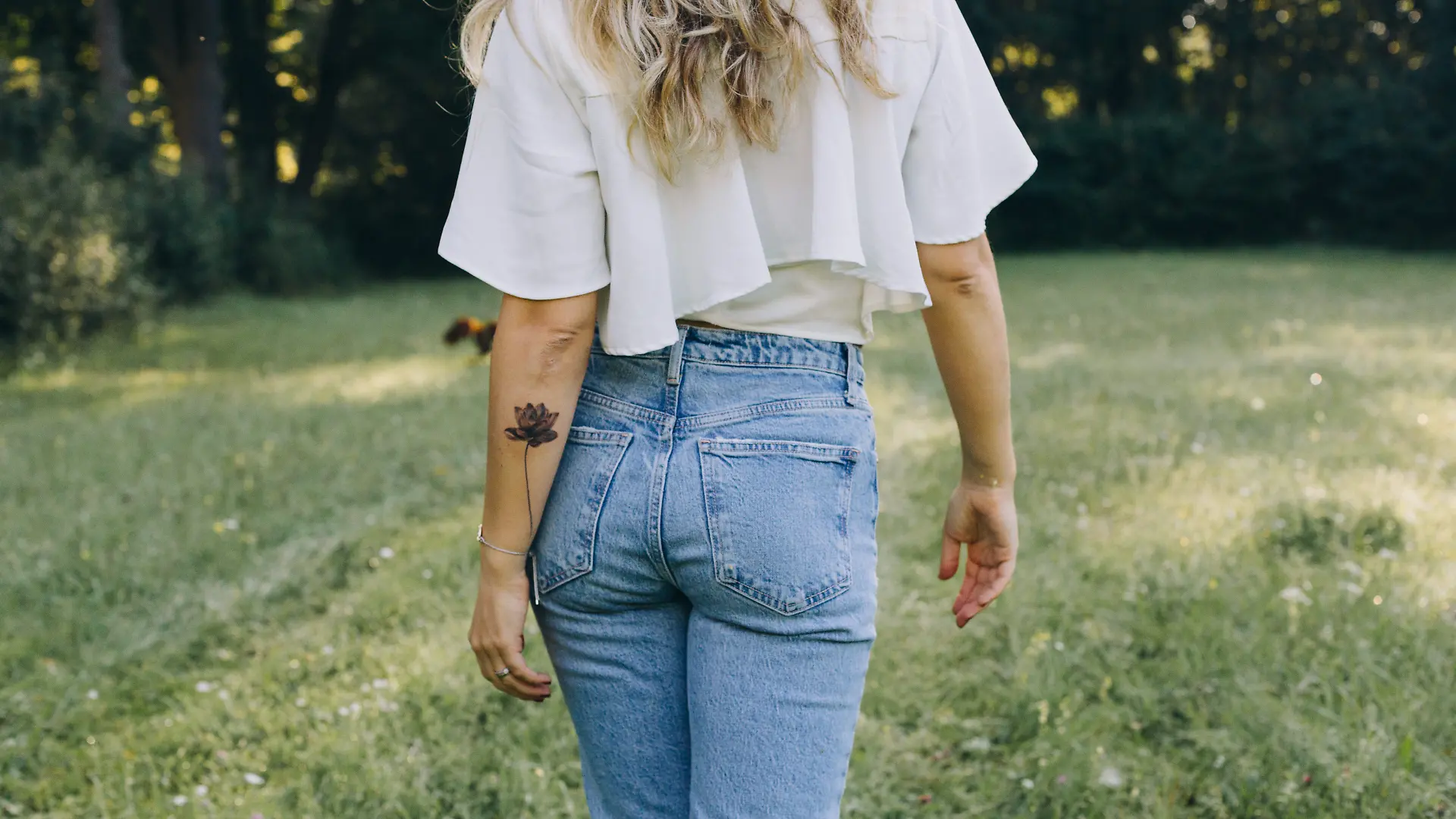 Porträts einer jungen Frau mit langen, blonden Haaren im Alter von 30 bis 34 Jahren in der Natur an einem Frühsommermorgen.