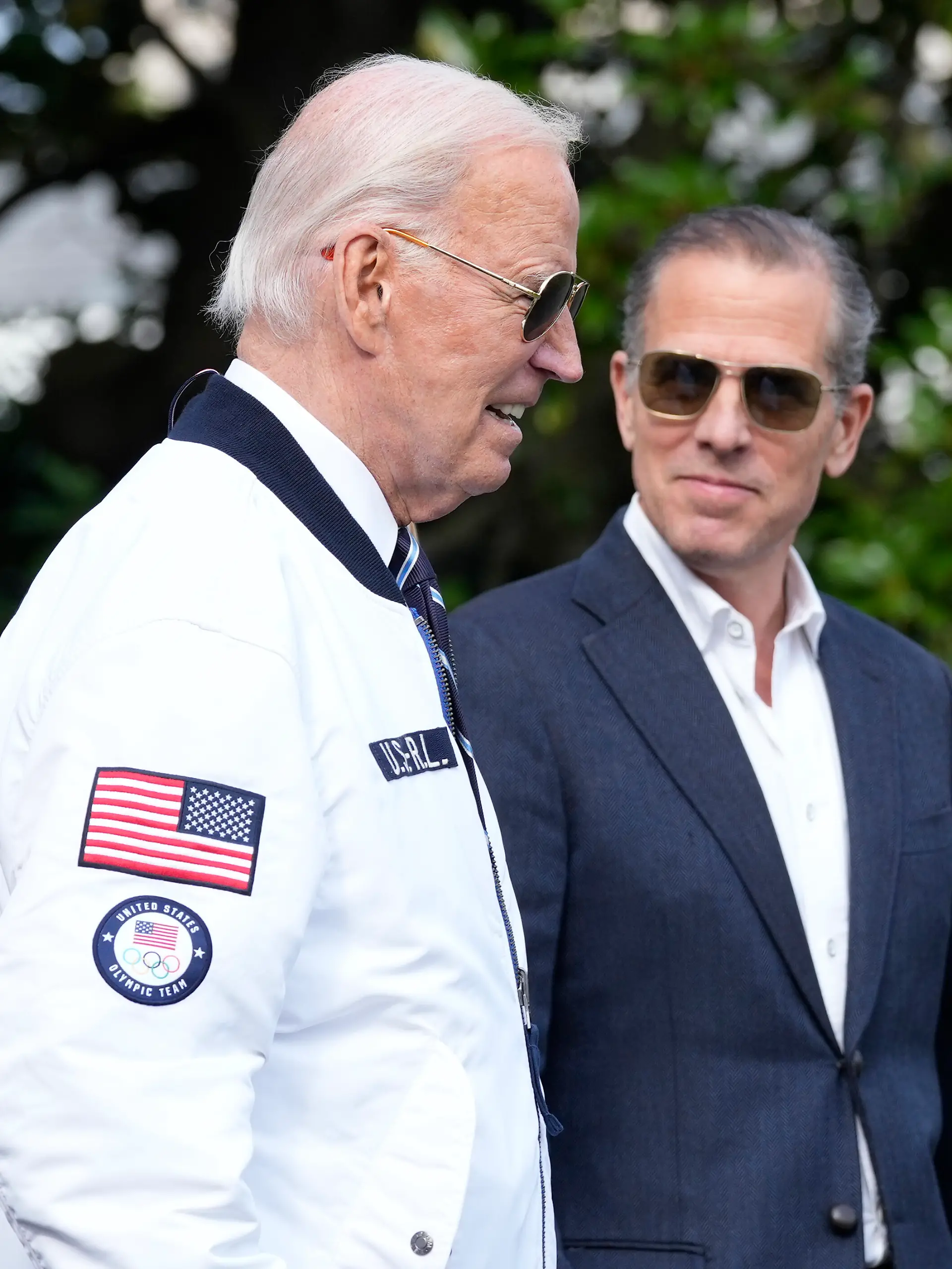 FILE - President Joe Biden, wearing a Team USA jacket and walking with his son Hunter Biden, heads toward Marine One on the South Lawn of the White House in Washington, July 26, 2024. (AP Photo/Susan Walsh, File)