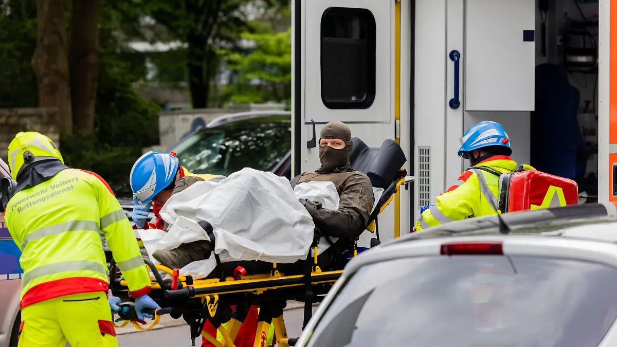 11.05.2023, Nordrhein-Westfalen, Ratingen: Ein verletzter Polizeibeamter wird vor einem Hochhaus in einen Krankenwagen gebracht. Bei einer Explosion in einem Hochhaus in Ratingen am Donnerstagvormittag wurden mehrere Menschen verletzt - darunter auch Polizisten und Einsatzkräfte der Feuerwehr. Foto: Rolf Vennenbernd/dpa +++ dpa-Bildfunk +++