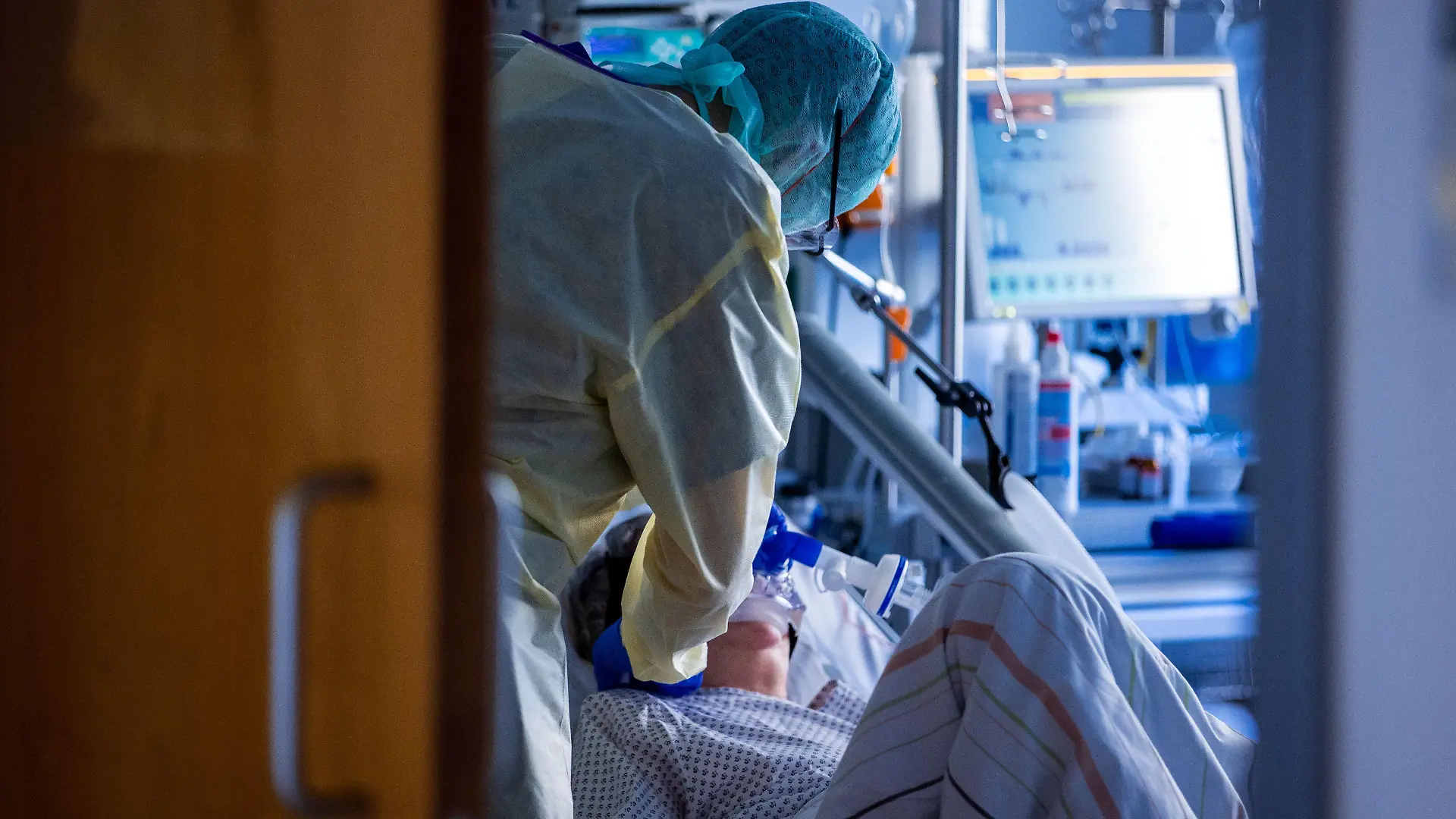 ARCHIV - 23.11.2020, Mecklenburg-Vorpommern, Greifswald: Eine Pflegekraft versorgt im besonders geschützten Teil der Intensivstation des Universitätsklinikums einen Corona-Patienten. Die Zahl der Neuinfektionen mit dem Coronavirus bleibt auf hohem Niveau. Innerhalb eines Tages wurden 16 643 neue Fälle übermittelt. Die deutschen Gesundheitsämter meldeten zudem 226 neue Todesfälle binnen 24 Stunden. Vor genau einer Woche hatte dieser Wert bei 188 gelegen. Foto: Jens Büttner/dpa-Zentralbild/dpa +++ dpa-Bildfunk +++