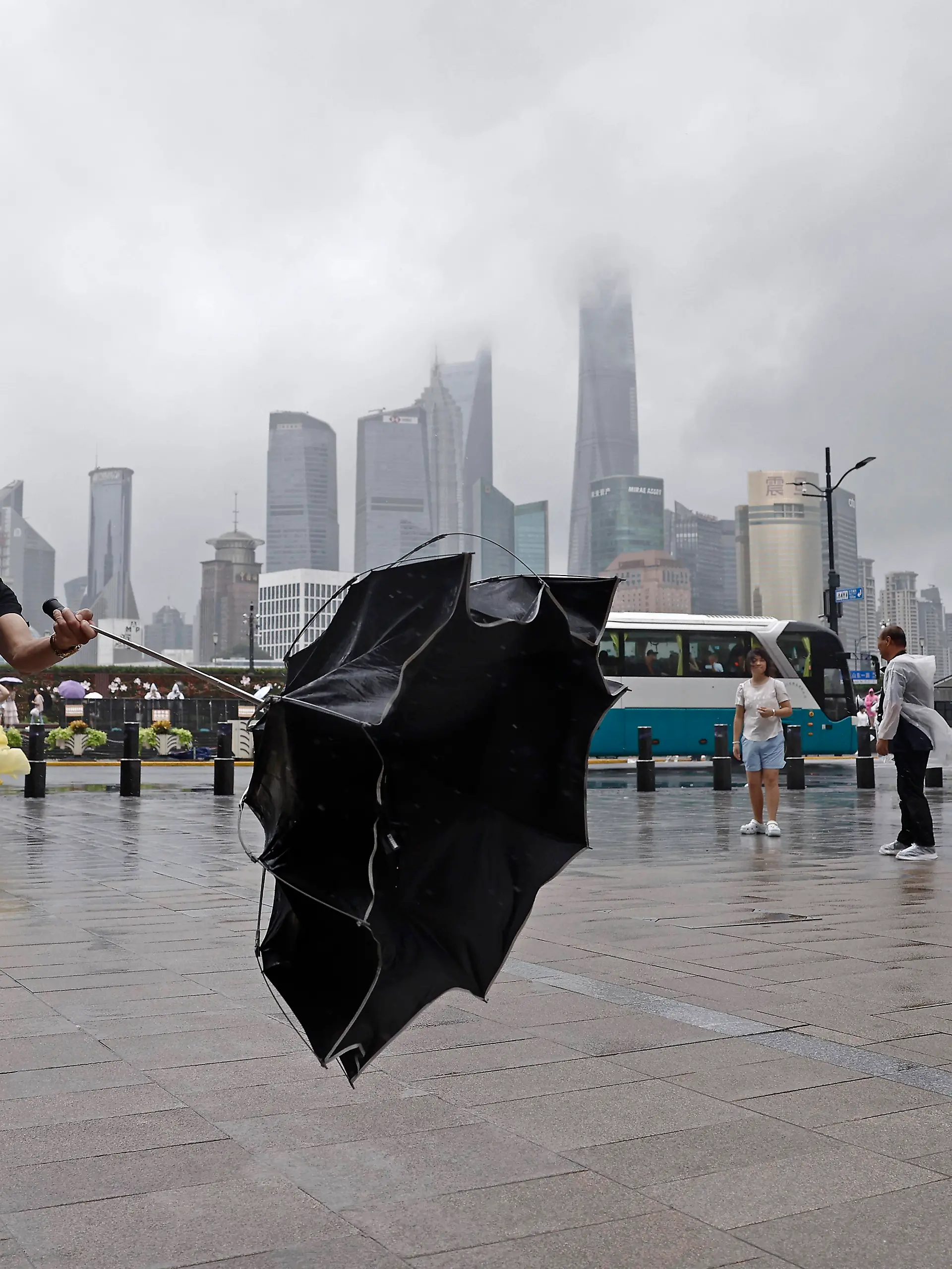SHANGHAI, CHINA - AUGUST 09: A tourist takes photos with mobile phone while experiencing strong winds on the Bund on August 9, 2026 in Shanghai, China. The Shanghai Meteorological Observatory upgraded the rainstorm warning signal for the central urban area from orange to red at 10:30 a.m. due to the impact of Typhoon Dolphin. PUBLICATIONxNOTxINxCHN Copyright: xChinaxNewsxServicex 111658975464