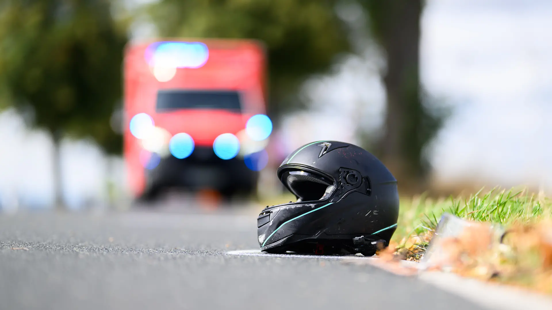 Der Helm einer Motorradfahrerin liegt nach einem Unfall auf der Straße