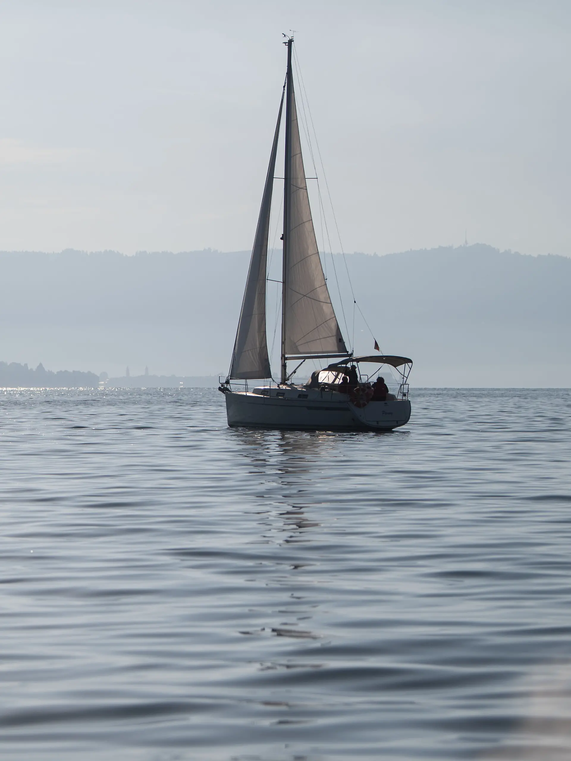 Ein Segelboot fährt auf dem Bodensee, auf dessen Wasser durch die Sonne glitzert. Ein Prozess um ein tödliches Schiffsunglück auf dem Bodensee, bei dem eine 57-jährige Deutsche ums Leben kam, soll neu aufgerollt worden. (zu dpa: «Tod einer Seglerin: 26-Jähriger unter Mordverdacht») +++ dpa-Bildfunk +++