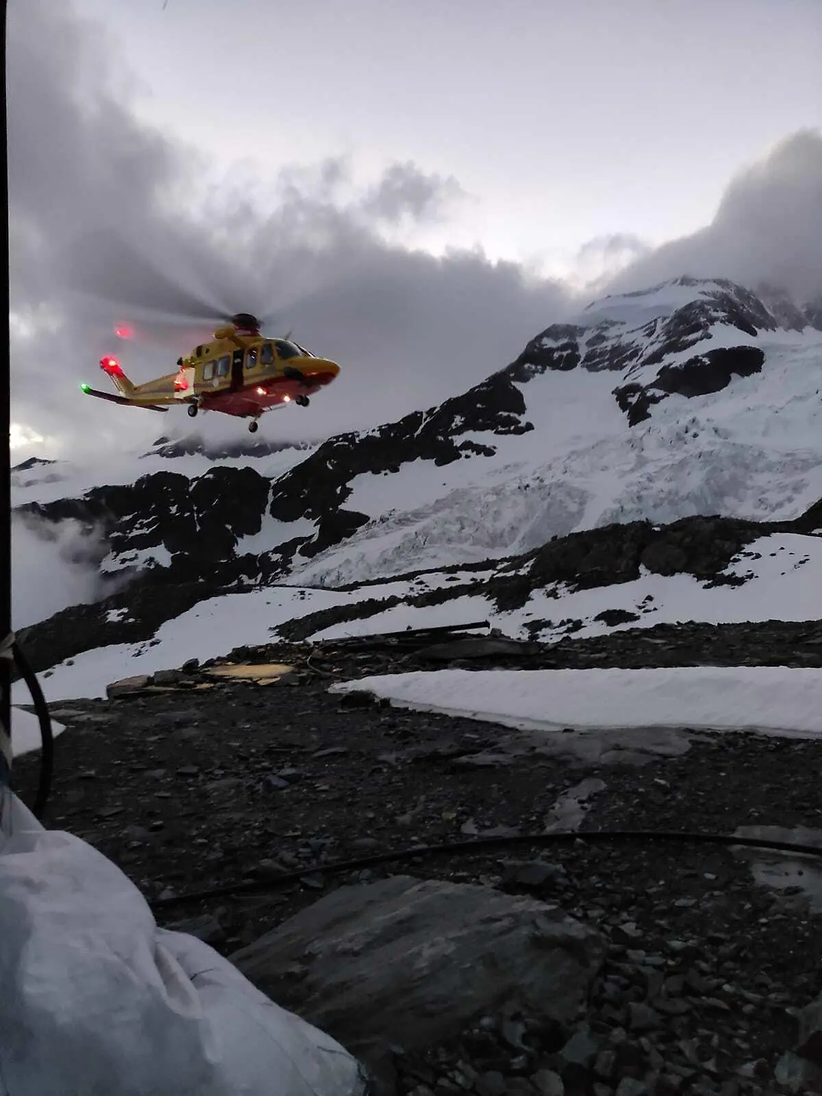 HANDOUT - 04.07.2021, ---, Monte Rosa: Handout zeigt einen Hubschrauber der  italienischen Bergwacht im Einsatz. Zwei Frauen sind in den Alpen an der italienisch-schweizerischen Grenze auf mehr als 4000 Metern Höhe erfroren. Ein Mann sei unterkühlt und mit Erfrierungen in der Nacht in ein Krankenhaus in der Schweiz geflogen worden, teilten die Bergretter des Aostatals im Nordwesten Italiens mit. Die drei waren auf dem Monte Rosa in den Walliser Alpen unterwegs. Foto: -/Corpo Nazionale Soccorso Alpino e Speleologico/dpa - ACHTUNG: Nur zur redaktionellen Verwendung im Zusammenhang mit der aktuellen Berichterstattung und nur mit vollständiger Nennung des vorstehenden Credits +++ dpa-Bildfunk +++
