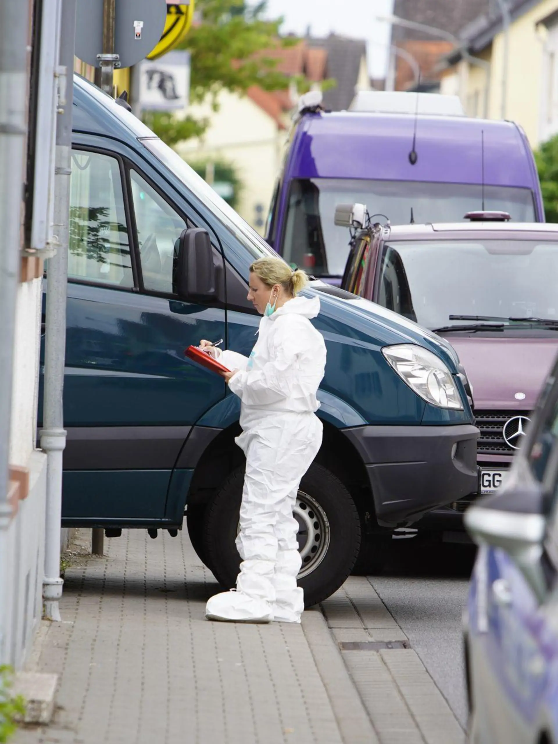 04.07.2021, Mörfelden-Walldorf: Eine Spurensicherin macht Notizen am Tatort. Die Polizei ist am Sonntag in einer Wohnung im südhessischen Mörfelden-Walldorf auf einen toten 19-Jährigen und seinen schwer verletzten Vater gestoßen. Foto: Felix Hirth/5Vision/dpa +++ dpa-Bildfunk +++