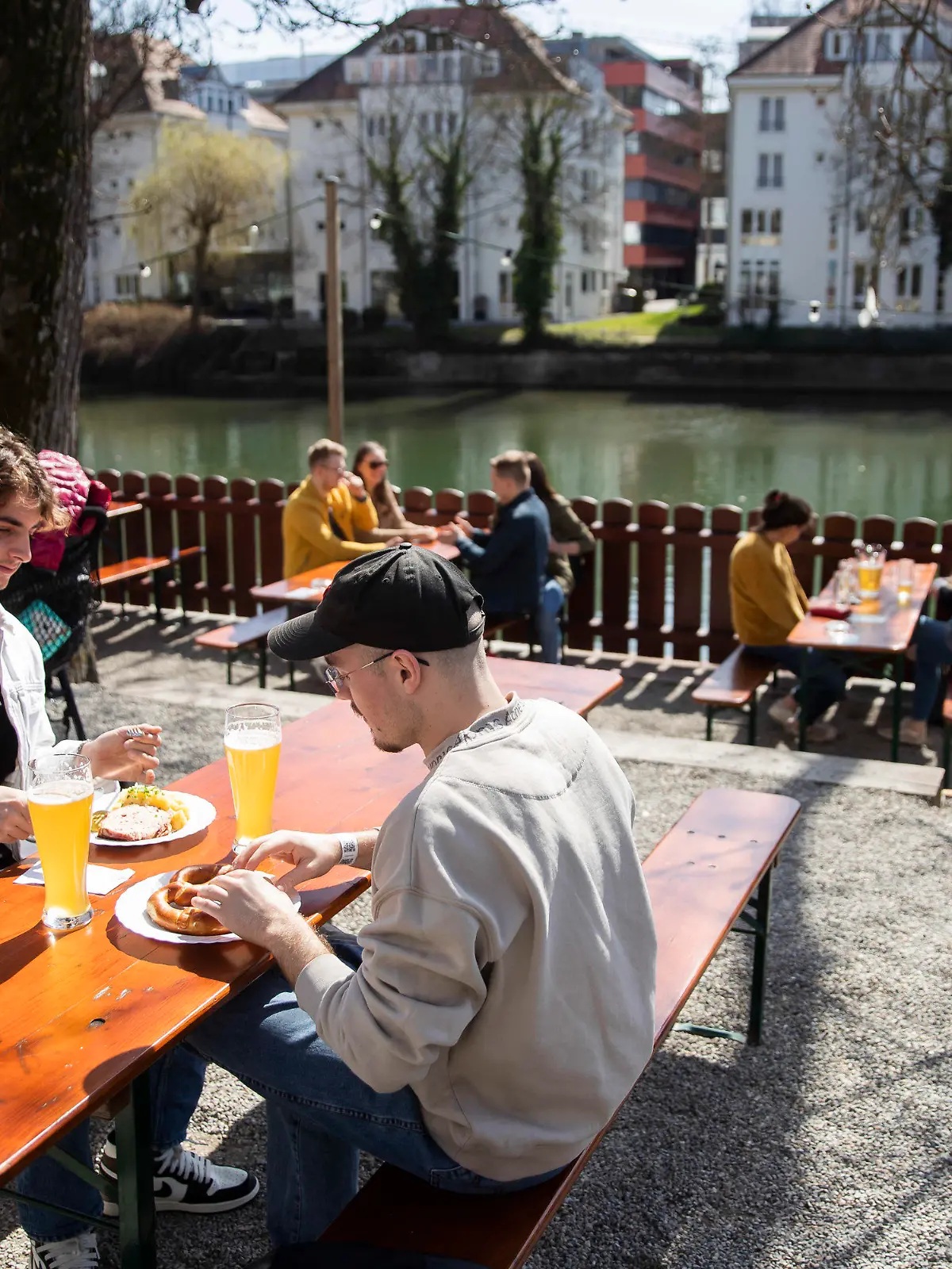 28.03.2021, Baden-Württemberg, Tübingen: Rouven (l) und Rene (r) sitzen bei gutem Wetter in einem Biergarten. In Tübingen können Menschen in der Stadt kostenlose Corona-Tests machen. Mit einem negativen Testergebnis können die getesteten Personen zum Beispiel in Modeläden einkaufen, zum Friseur oder auch in der Außengastronomie bewirtet werden. Foto: Tom Weller/dpa +++ dpa-Bildfunk +++