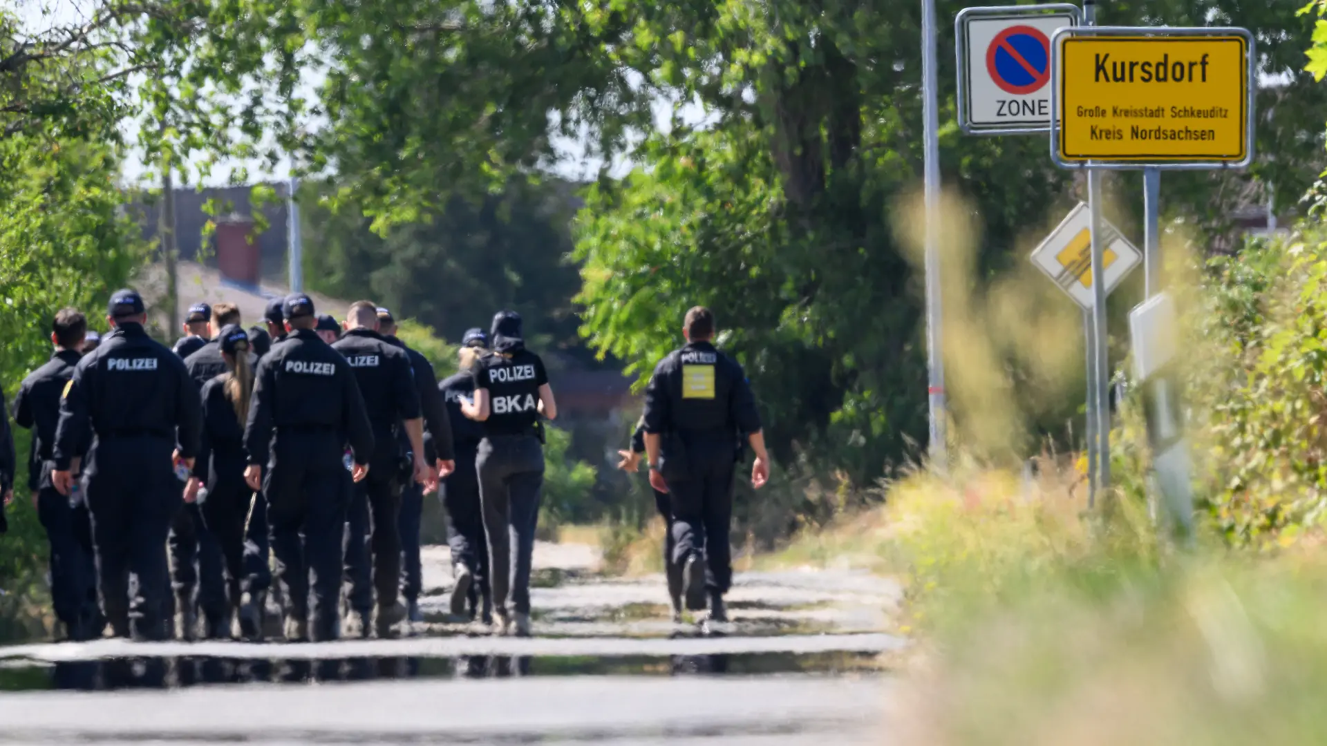 Einsatzkräfte der Polizei und des BKA suchen am Flughafen Leipzig/Halle nahe dem Ort Kursdorf nach Spuren. Nach dem Drohnenvorfall in der Nacht zum Mittwoch (05.08.) laufen die Ermittlungen. Die für einen Angriff ausgerüstete Drohne war nach Angaben aus Sicherheitskreisen nahe einer ukrainischen Transportmaschine sichergestellt worden. (Unschärfe durch Hitzeflimmern bei Aufnahme aus größerer Distanz).