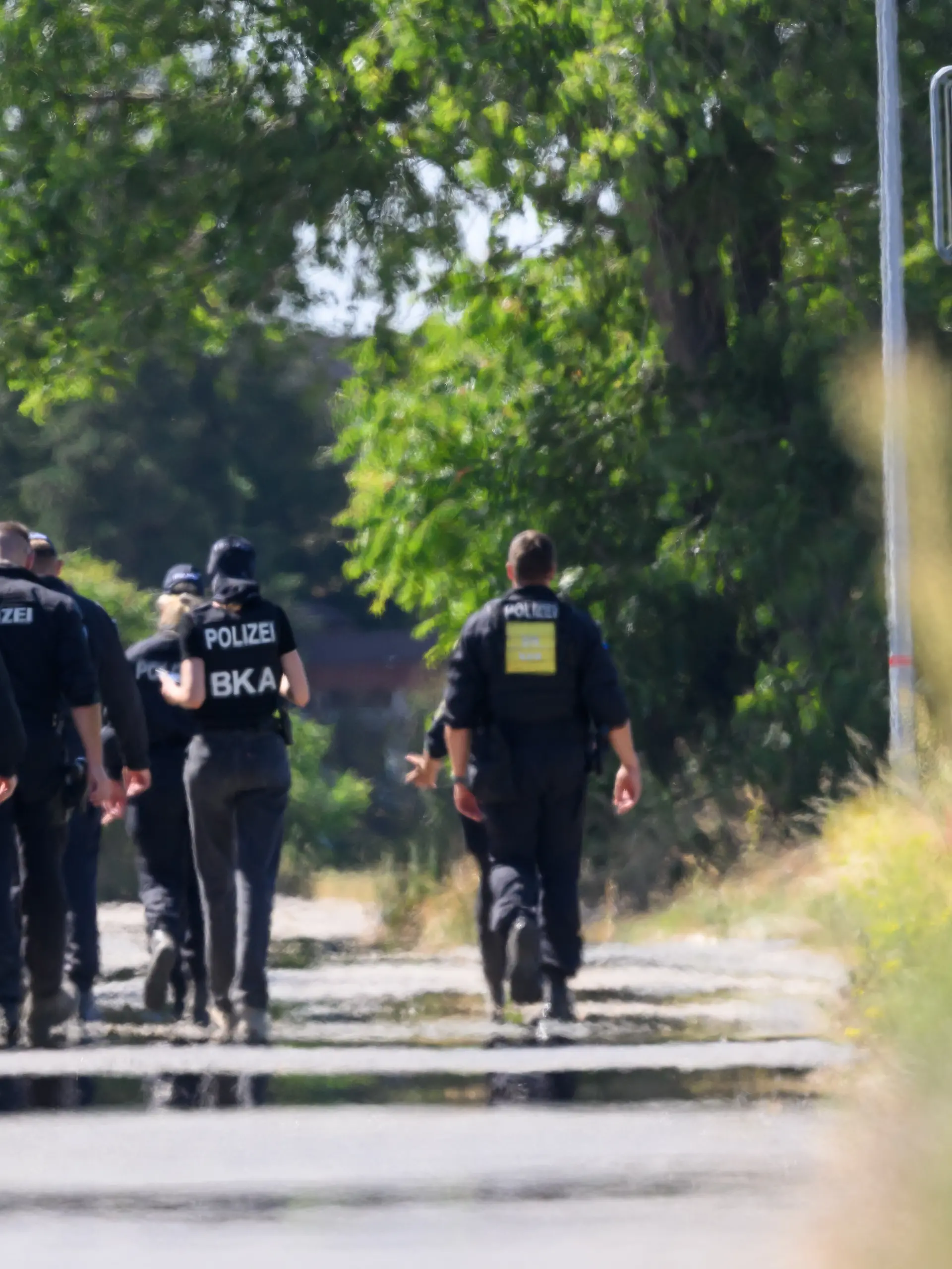 Einsatzkräfte der Polizei und des BKA suchen am Flughafen Leipzig/Halle nahe dem Ort Kursdorf nach Spuren. Nach dem Drohnenvorfall in der Nacht zum Mittwoch (05.08.) laufen die Ermittlungen. Die für einen Angriff ausgerüstete Drohne war nach Angaben aus Sicherheitskreisen nahe einer ukrainischen Transportmaschine sichergestellt worden. (Unschärfe durch Hitzeflimmern bei Aufnahme aus größerer Distanz).
