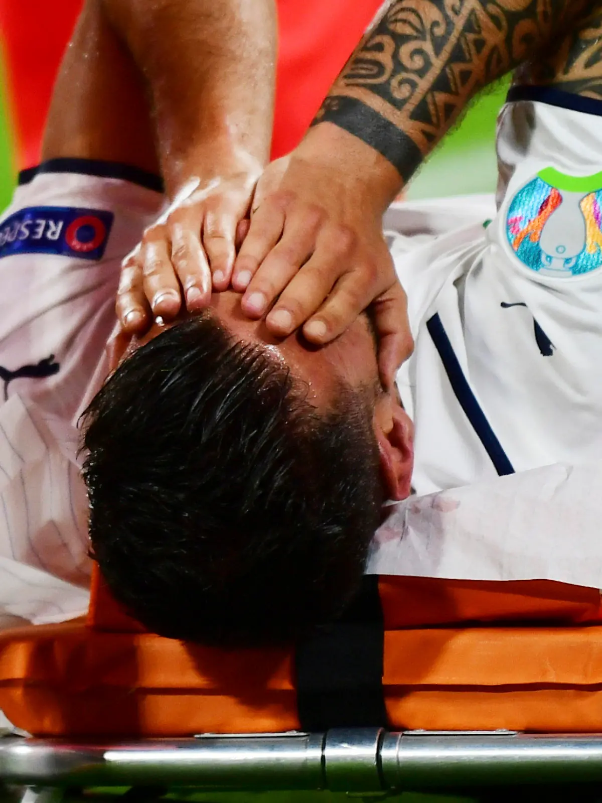 Italy's Leonardo Spinazzola covers his face after injuring during the Euro 2020 soccer championship quarterfinal match between Belgium and Italy at at the Allianz Arena in Munich, Germany, Friday, July 2, 2021. (AP Photo/Philipp Guelland, Pool Photo via AP)