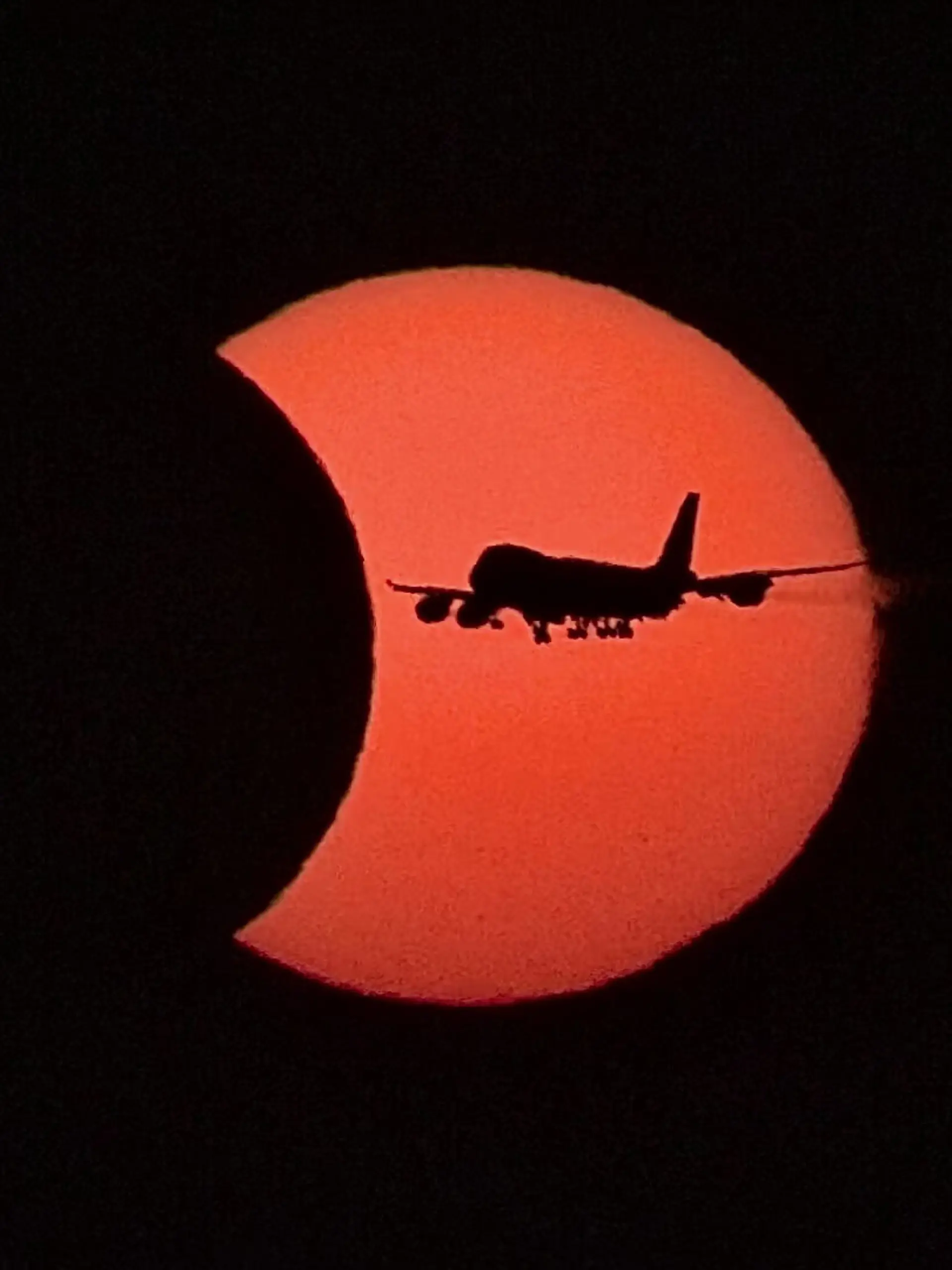 Ein Flugzeug vom Typ Boeing 747 fliegt während der partiellen Sonnenfinsternis vor der teilweise vom Mond verdeckten Sonne. +++ dpa-Bildfunk +++